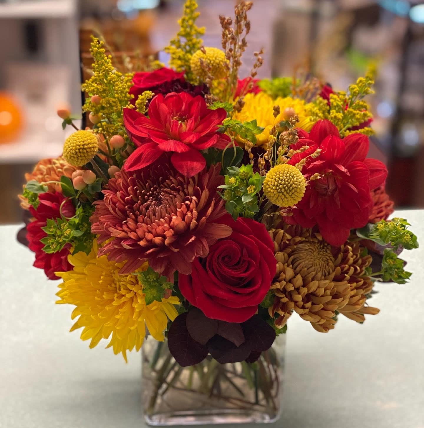 Autumn Day - Roses, mums, billy balls, solidago, burplerum in a clear glass cube