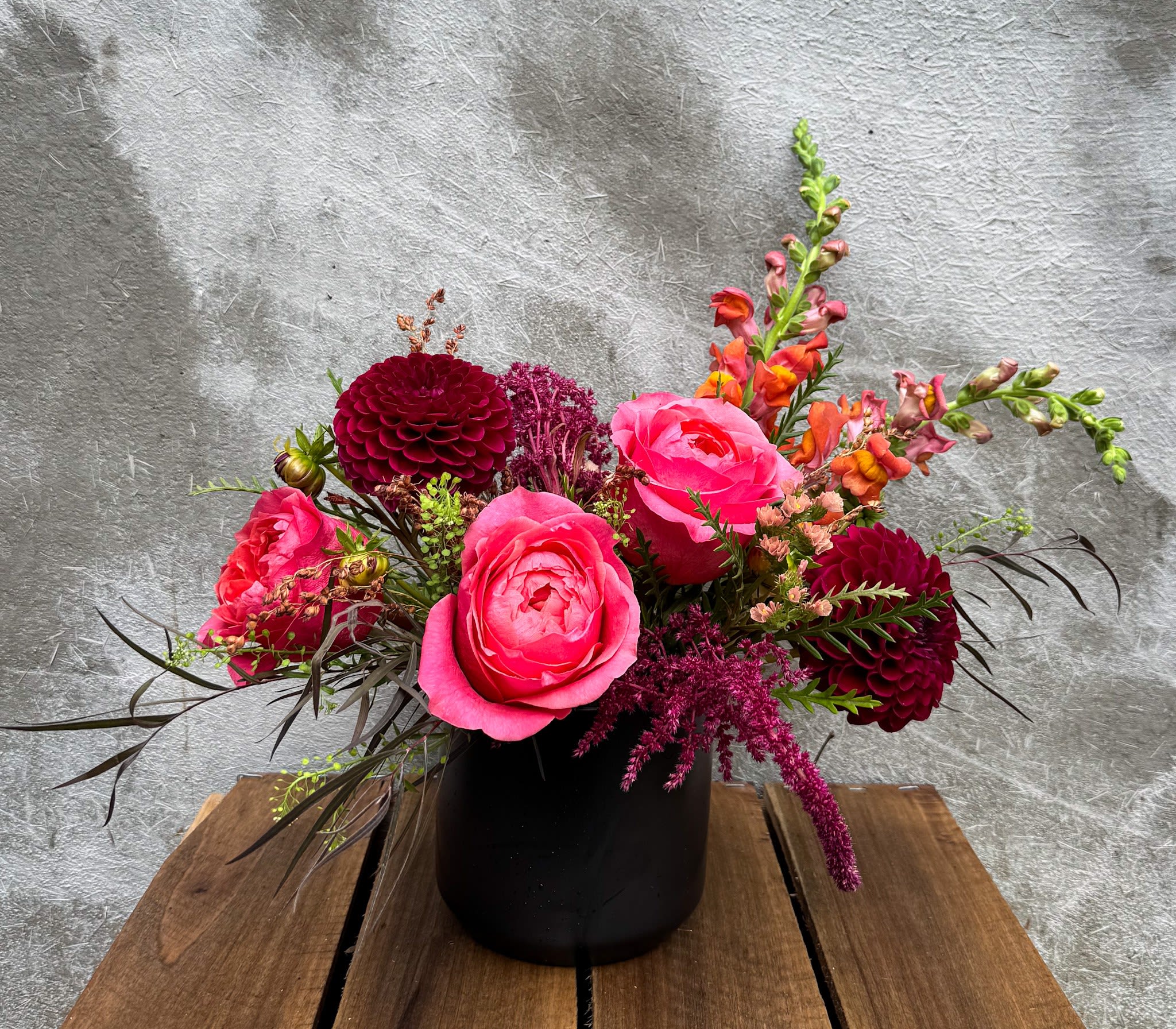 Spellbound - Luxurious tones of reds and pinks fill a timeless black ceramic vessel.  Standard size measures approximately 10&quot; x 10&quot;. 
