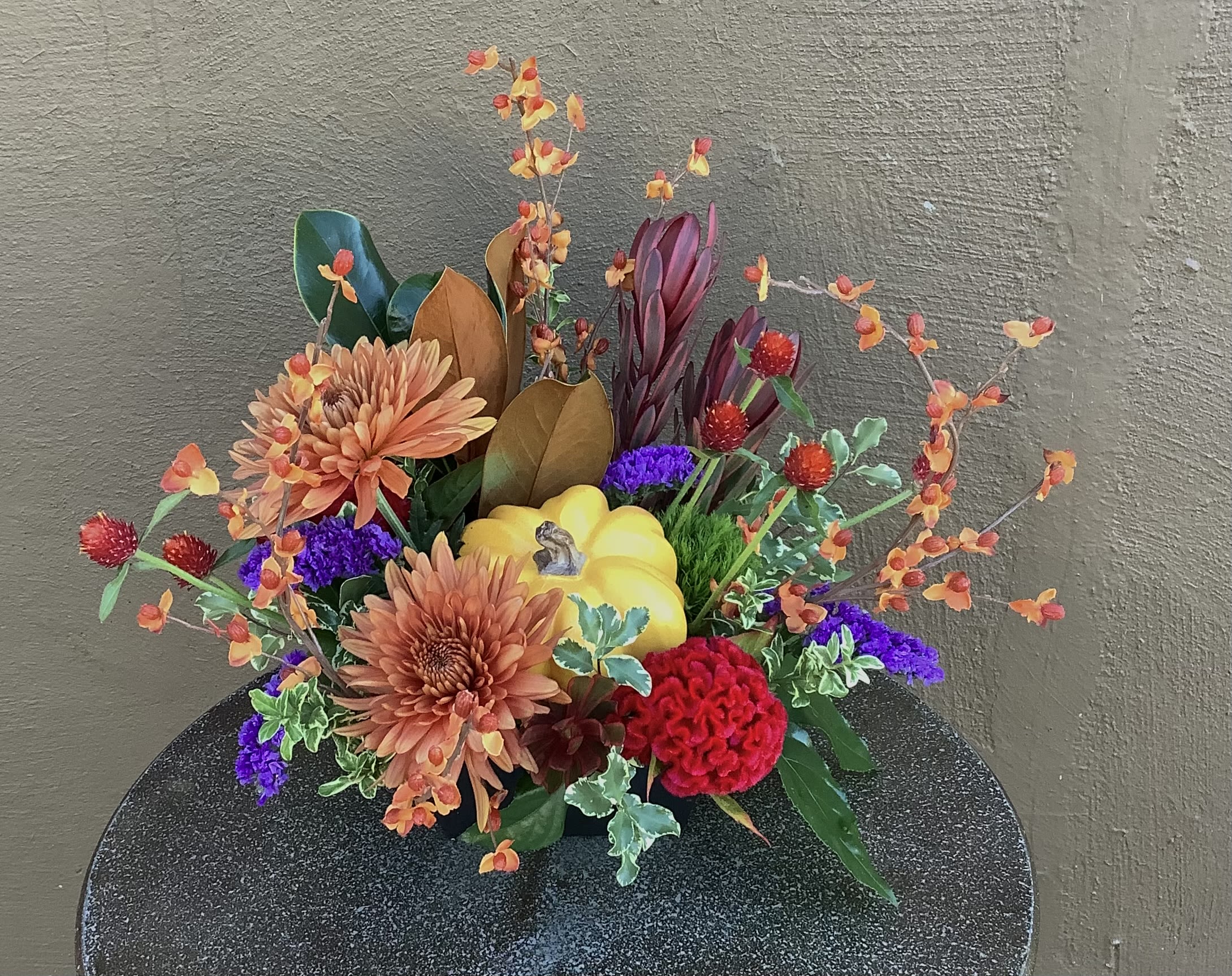 Bring on the Pie - This cute yellow pumpkin is nestled among a bountiful mix of fall flowers and foliages.