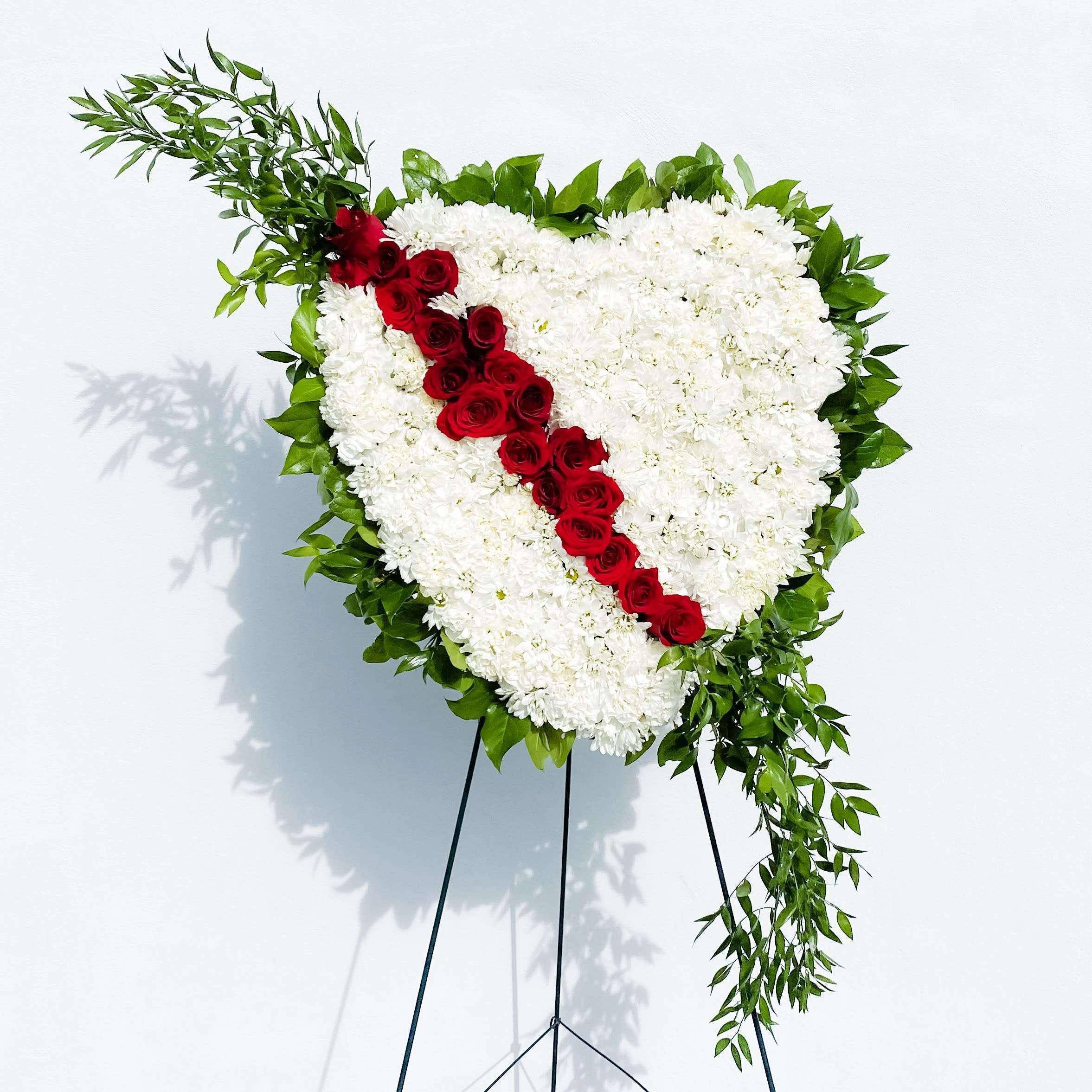 Bleeding Heart Spray by DGM Flowers Bleeding Heart Spray by DGM Flowers - Express your condolences with a solid Bleeding heart spray arrangement of daisies, carnations, roses and ruscus. Arranged by our designer into a heart standing spray, this is a beautiful arrangement to send to a friend or family member during this difficult time. Measures 20"H x 25"W x 6"D.