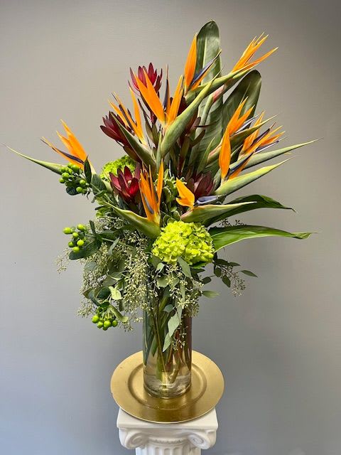 TROPICAL PARADISE TROPICAL PARADISE - Tropical Paradise is designed in a tall cylinder style clear glass vase. This is sure to be a show stopper no matter the occasion. This design requires at least 24 hours notice.