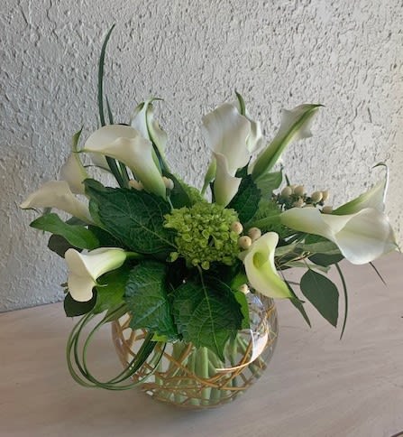 Calla Lily Bowl  (DL) - For a truly original gift, choose this glass bubble bowl lined with vines and topped with an eye-catching arrangement of pure white mini Calla lilies, Hypericum  berries, green mini Hydrangea and assorted greenery.
