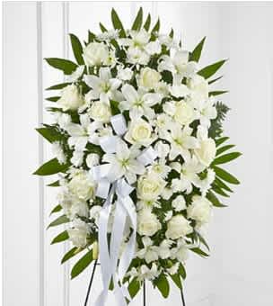 Exquisite Tribute (DL) - Create an elegant and timeless tribute with our standing spray adorned with white roses, white lilies, and white pom daisies, perfectly displayed on an easel with premium leather leaf. This stunning arrangement exudes a sense of purity, grace, and eternal love, serving as a beautiful expression of remembrance and honor for your cherished loved one.