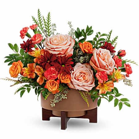 Copper Celebration Centerpiece - Celebrate the season with warmth and charm. Teleflora's Copper Celebration Centerpiece captures fall's cozy glow with rich orange blooms and lush textures, beautifully arranged in a copper-finished planter with wooden stand-perfect for Thanksgiving gatherings and autumn moments