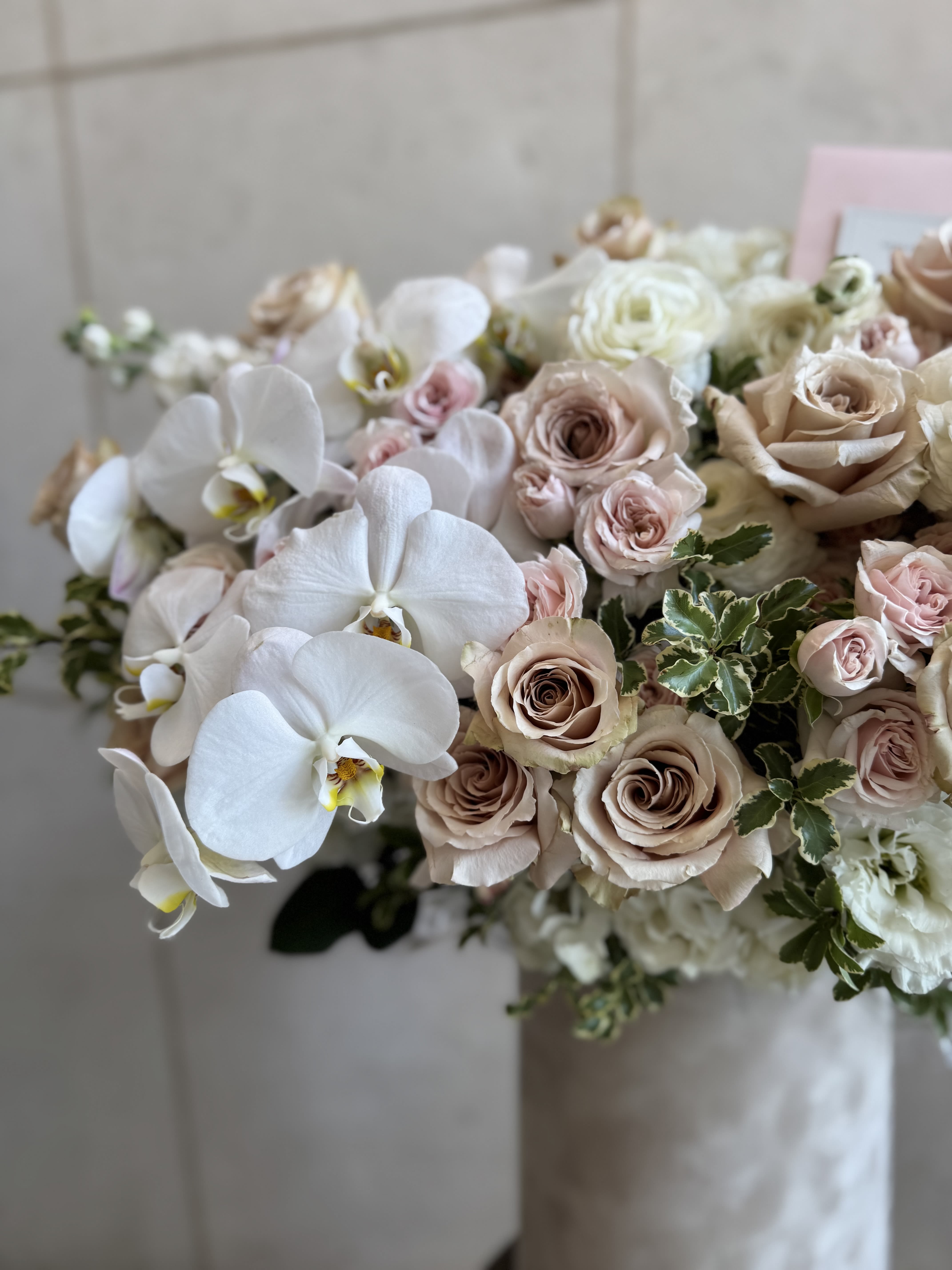 Château box with orchids - This arrangement features elegant beige nude Quicksand roses with lush garden roses, delicate ranunculus, and white orchids. Accented with lisianthus and fresh greenery, all beautifully arranged in a luxurious beige velvet box!