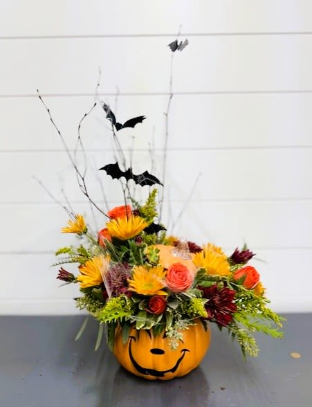 Hocus Pocus (LOCAL DELIVERY AND PICK UP ONLY) Hocus Pocus (LOCAL DELIVERY AND PICK UP ONLY) - Seasonal colored mums, spray roses, yellow solidago, greenery, adorned with spooky bats, sticks, and cobwebs in a ceramic Jack-O-Lantern keepsake container.