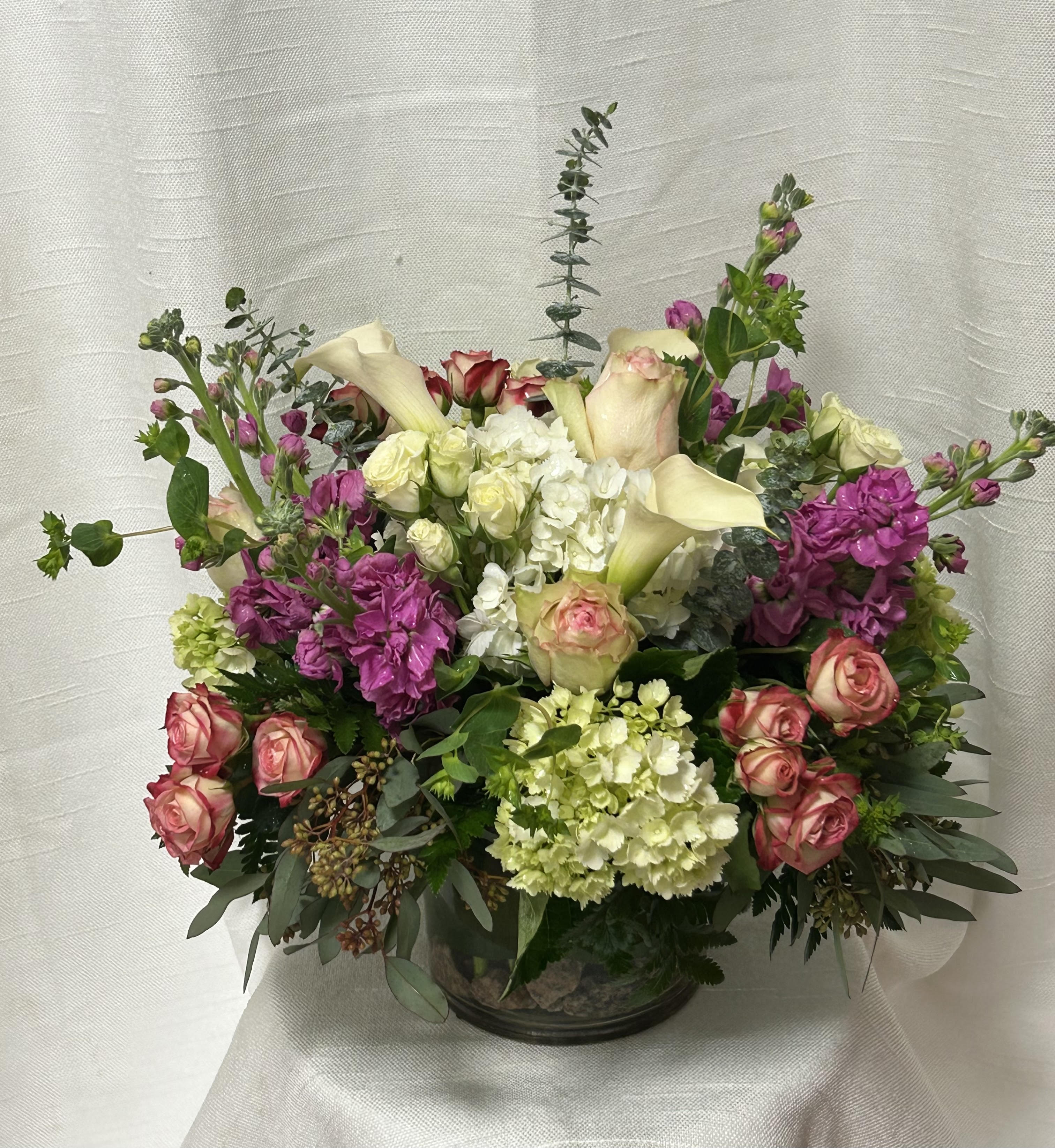 Beauty of Boca Raton (BR) - Introducing our premium floral arrangement, dazzling with shades of green, white, pink and lavender. This stunning ensemble features green and white hydrangeas, white calla lilies, lavender stock, pink roses, eucalyptus, and assorted greenery.
