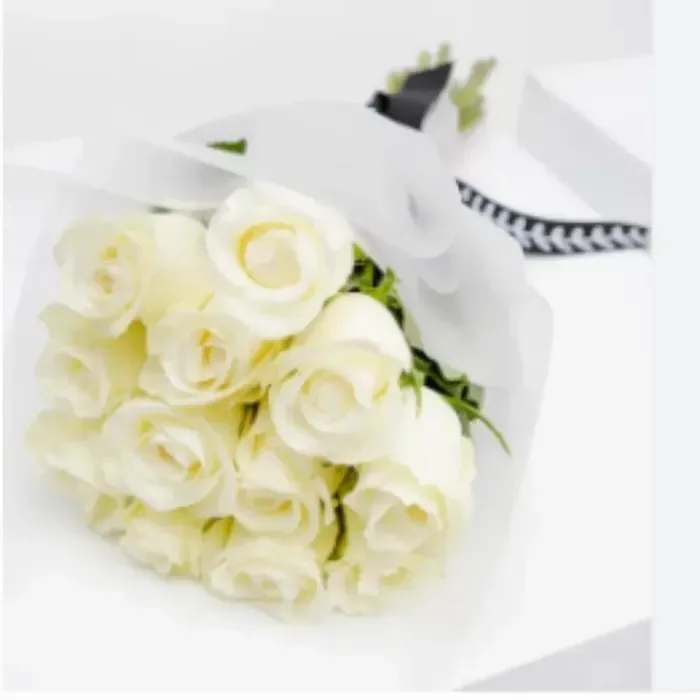 Dozen White Roses Wrapped Dozen White Roses Wrapped - A simple and elegant hand-tied bouquet featuring twelve pristine white roses, beautifully complemented by lush greenery. Perfect for expressing love, sympathy, or timeless grace.