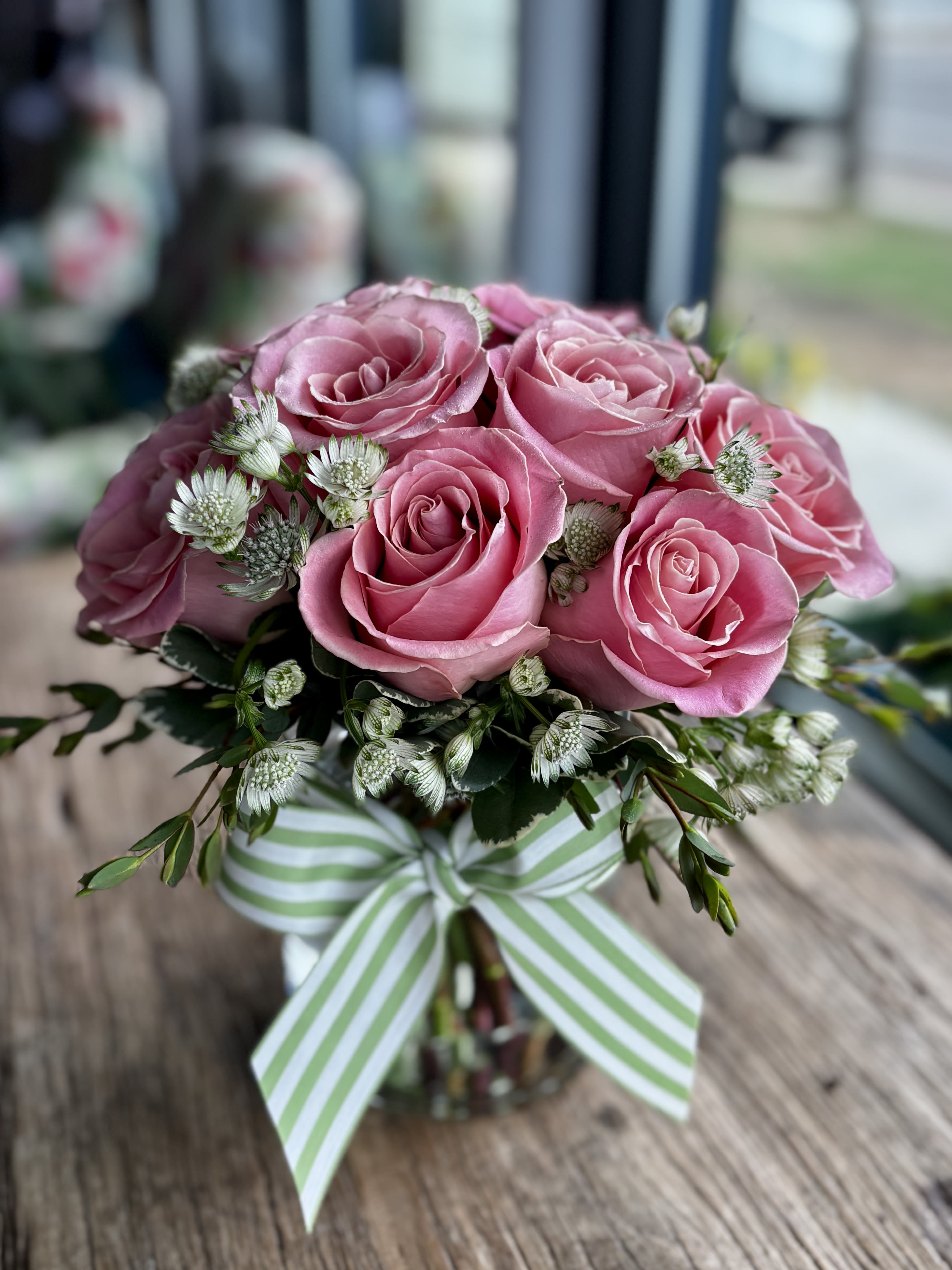 Modern Pink Dozen - 12 premium pink roses in a low and lush style! Perfect for any occasion, this is a modern take on a traditional design; not your typical 'long stem style.' Pictured vase is 6.5&quot; tall.  Also available in: light pink, yellow, white, orange, and peach. If you would like a color other than medium pink, please specify the desired color in the special instructions box during check out. Vase may vary.