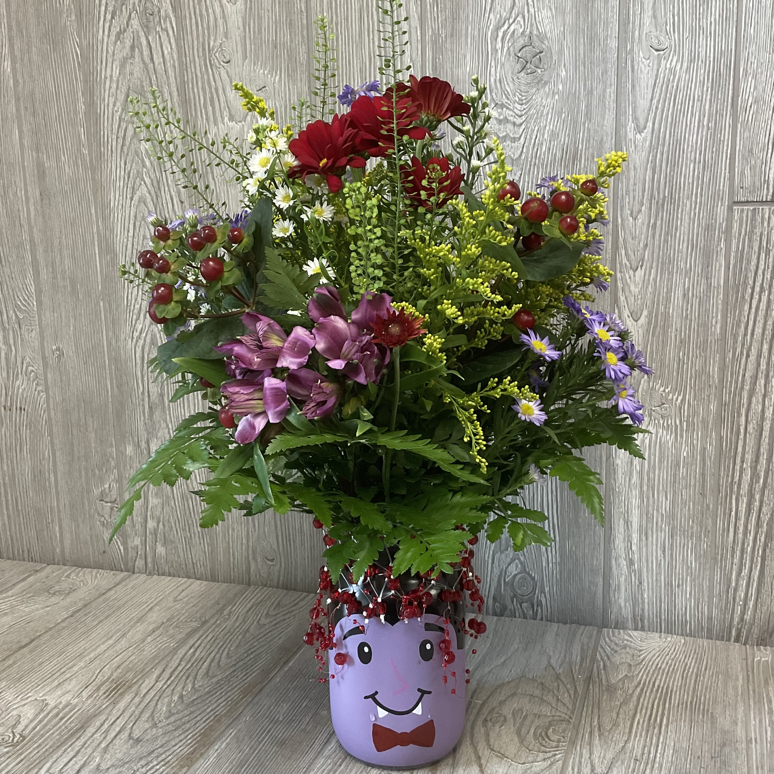 Dracula Wildflower  - Arranged in a keepsake Dracula glass jar with spooky Halloween inclusions. Unique wildflower arrangement designed to look like the flowers were fresh picked along the way. Each one is uniquely made making it to where no two are alike.