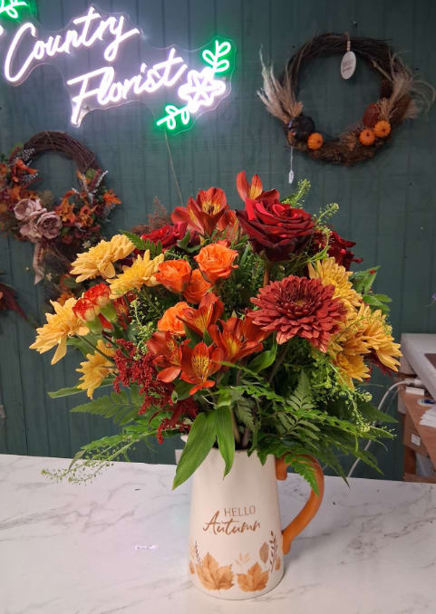 Hello Autumn Hello Autumn - Embrace the cozy charm of the season with our Hello Autumn arrangement — a radiant celebration of fall’s golden hues. Bursting with rich, seasonal blooms in warm oranges, deep reds, and sunny yellows, this design captures the heart of autumn in full color. Artfully arranged in a beautiful ceramic pitcher, it’s perfect for adding a touch of rustic elegance to your home or gifting to someone special. Once the blooms have faded, the keepsake pitcher makes a lovely piece for fresh flowers, cider, or simply as a charming fall accent. Please note: Flowers and colors will vary based on seasonal availability. If you have specific preferences, kindly include them in the “Special Instructions” section when placing your order.