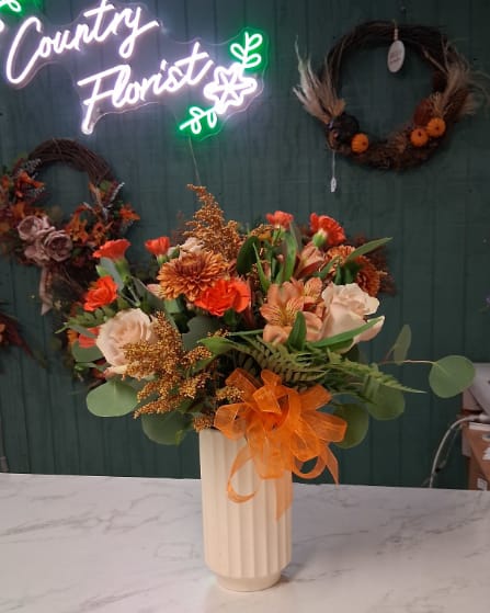 Country Girl Country Girl - Celebrate the sweet charm of the countryside with our Country Girl arrangement — a heartfelt blend of rustic beauty and feminine grace. Designed in a lovely cream ceramic pillar container, this arrangement overflows with lush seasonal blooms in soft, romantic tones that capture the spirit of a true country girl. Perfect for birthdays, just-because moments, or simply to brighten someone’s day, this piece brings a touch of warmth and country elegance to any space. Please note: Flowers and colors will vary based on seasonal availability. If you have specific preferences, kindly include them in the “Special Instructions” section when placing your order.