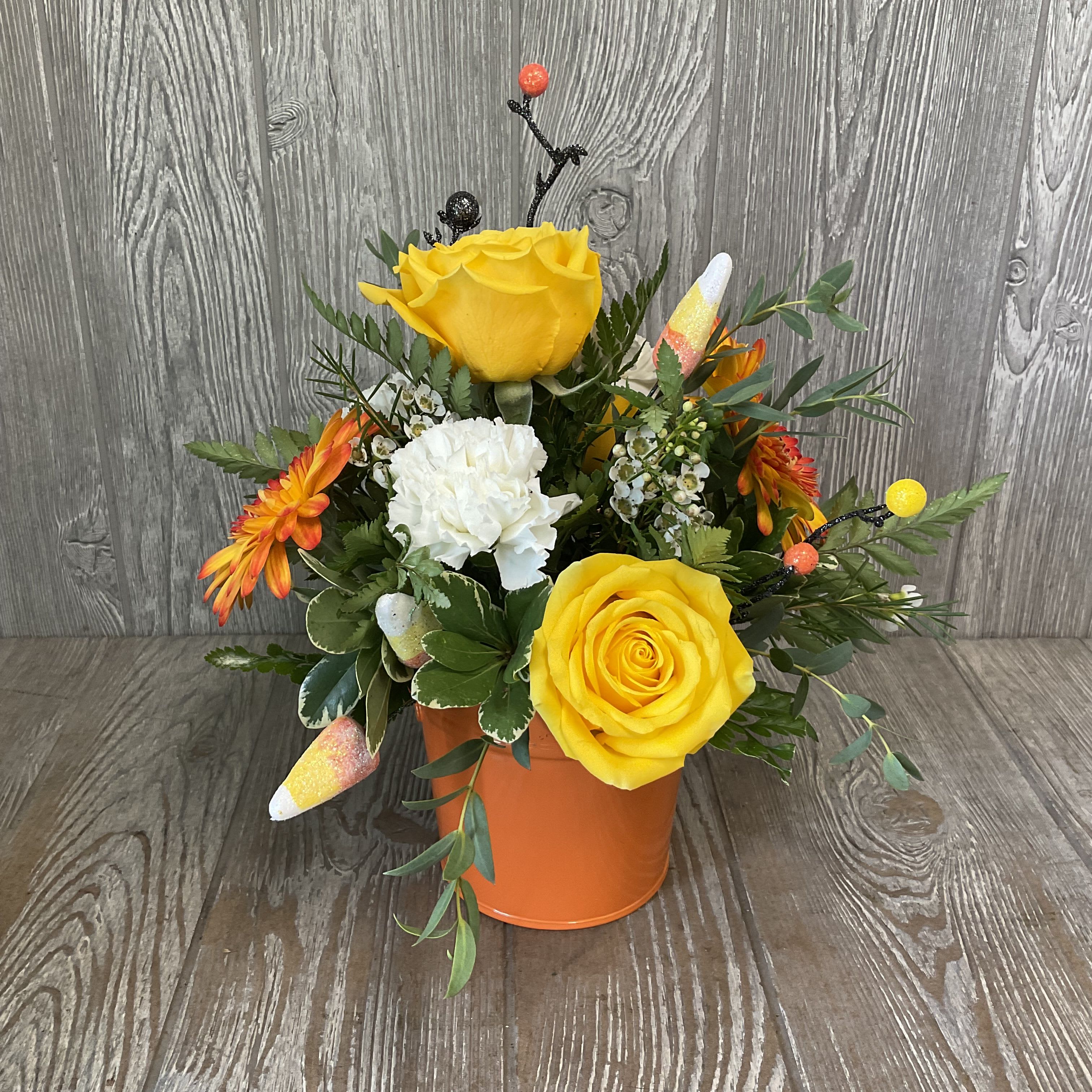 Candy Corn - Fun and festive candy corn arrangement in an orange container perfect for the candy corn lover in your life. Colors and flowers may vary. 