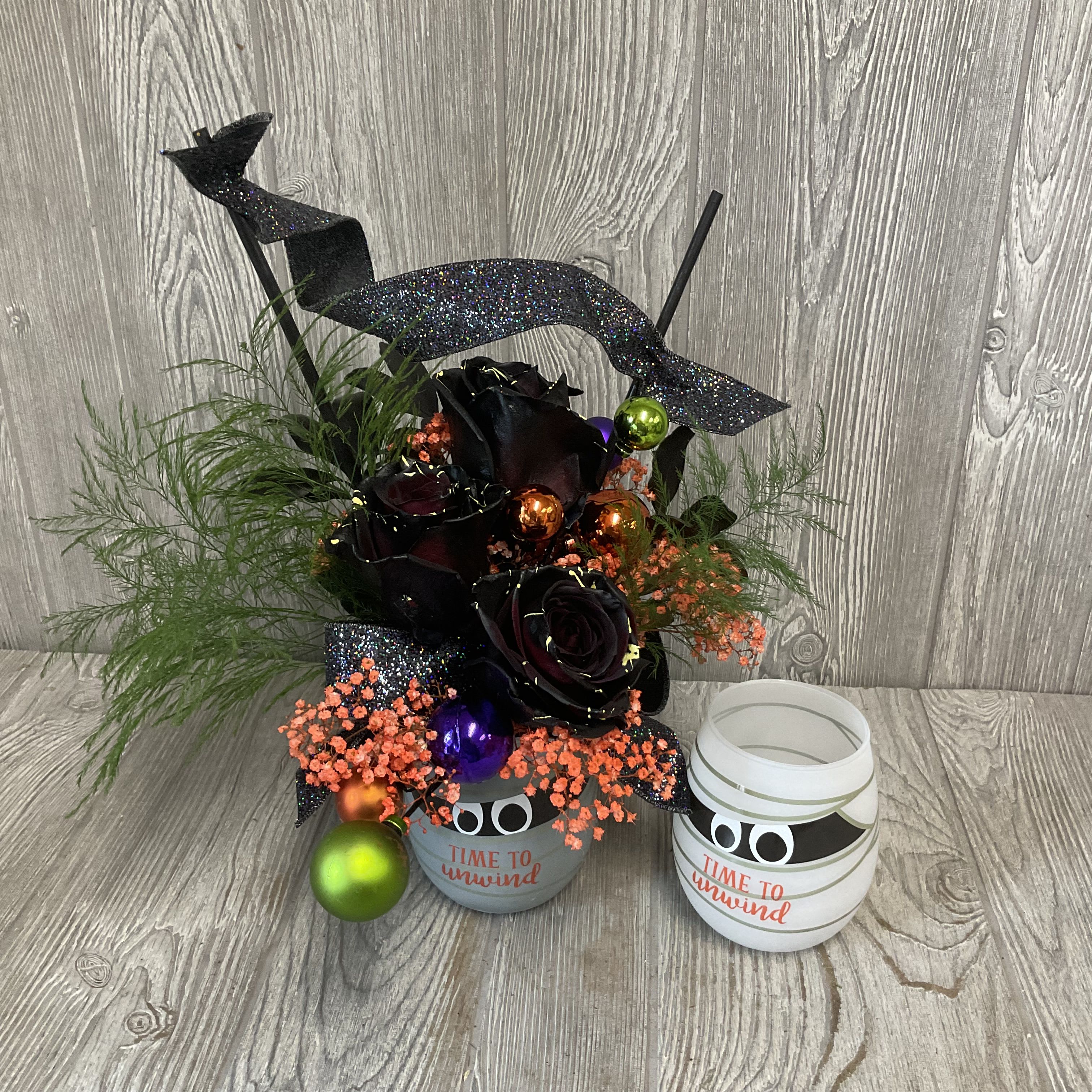 Time to Unwind - Fresh cut flowers arranged in a keepsake mummy wine glass. Perfect for this Halloween season! Flowers and colors may vary. 