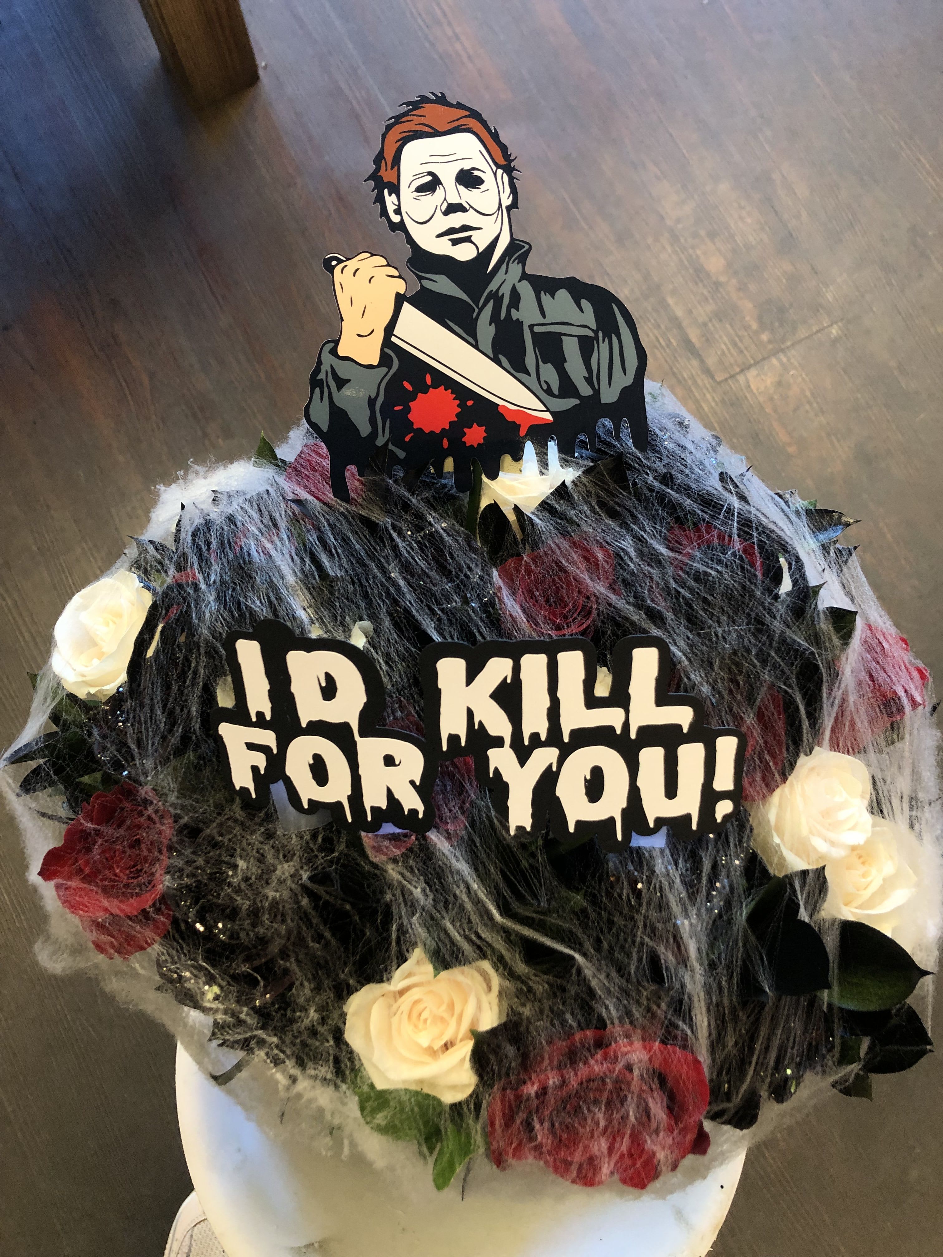 HALLOWEEN WRAP (MICHAEL MYERS CUT OFF) NO VASE INCLUDED HALLOWEEN WRAP (MICHAEL MYERS CUT OFF) NO VASE INCLUDED - 24 TOTAL ROSES, MIXED COLORS SUCH AS RED, WHITE AND BLACK ROSES (THE BLACK ROSES ARE SPRAYED PAINTED BLACK) AND BLACK RUSCUS. WE ADD BOTH OF THE CUT OFFS WHICH IS THE MICHAEL MYERS ( ABOUT 5 INCHES TALL) AND THE (ID KILL FOR YOU) CUT OFF. ALL WRAPPED IN BLACK PAPER