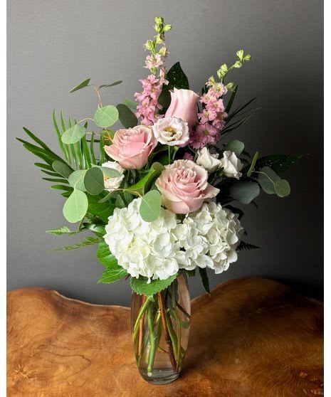 Timeless Grace -  Timeless Grace – Elegant Floral Arrangement   Bring elegance and sophistication into any space with our Timeless Grace Floral Arrangement, a stunning blend of soft pink roses, lush white hydrangeas, delicate lisianthus, and fresh greenery. Presented in a chic glass vase, this arrangement is perfect for any occasion, from heartfelt gifts to stylish home décor.   Why You’ll Love It:  Handpicked Fresh Blooms – Long-lasting and beautifully arranged  Classic &amp; Sophisticated Design – A perfect blend of soft pastels and natural greens  Ideal for Every Occasion – Birthdays, anniversaries, sympathy, or home elegance  Fast &amp; Reliable Delivery – Order online and enjoy effortless floral beauty   Shop now &amp; bring timeless elegance to any moment!
