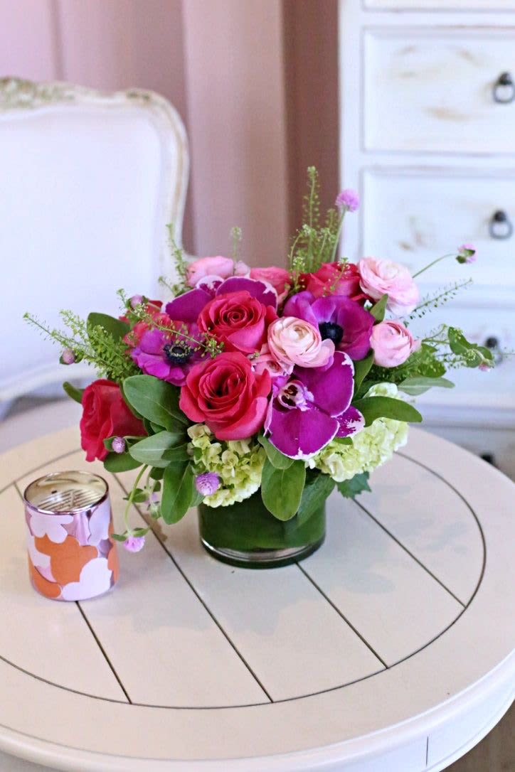 Vibrant Floral -  Bold Beauty – Vibrant Floral Arrangement   Make a statement with our Bold Beauty Floral Arrangement, a stunning mix of deep pink roses, lush hydrangeas, exotic orchids, and delicate ranunculus. Designed in a modern glass vase, this vibrant bouquet brings luxury and charm to any space.   Why You’ll Love It:  Fresh, Handpicked Blooms – Vibrant, long-lasting, and fragrant  Striking &amp; Elegant Design – A bold mix of pinks, purples, and greens  Perfect for Any Occasion – Birthdays, anniversaries, romantic surprises, or home décor  Fast &amp; Secure Delivery – Order online and send a breathtaking floral gift   Shop now &amp; let your love bloom in vibrant colors!