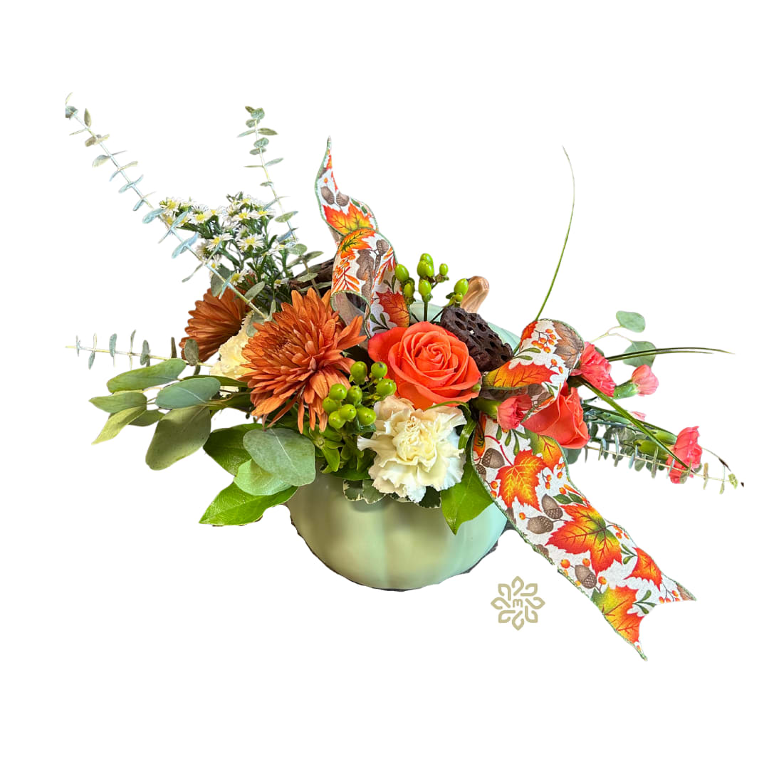 Autumn Embrace Pumpkin - Capture the essence of fall with our &quot;Autumn Embrace Bouquet,&quot; a beautifully curated floral arrangement that brings the warmth and coziness of the season into your home. This exquisite bouquet features a harmonious blend of carnations, cremones, and roses, all beautifully complemented by monte, lotus pods, eucalyptus, and hypericum. Nestled in a charming ceramic sage pumpkin container and adorned with a decorative fall ribbon, this arrangement is the perfect centerpiece for any autumn occasion.