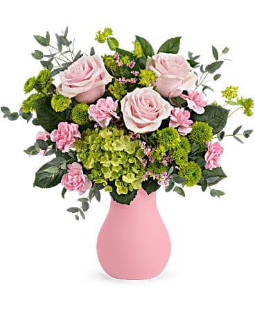 Teleflora's Breezy Pink Bouquet - Bursting from a frosted pink glass vase, this playful pop of pretty pink roses and fresh green hydrangea is as refreshing as a breezy spring day! This breezy bouquet includes pink roses, miniature green hydrangea, green button spray chrysanthemums, miniature pink carnations, pink limonium, bupleurum, parvifolia eucalyptus and lemon leaf. Delivered in Teleflora's Serendipity Glass Vase.