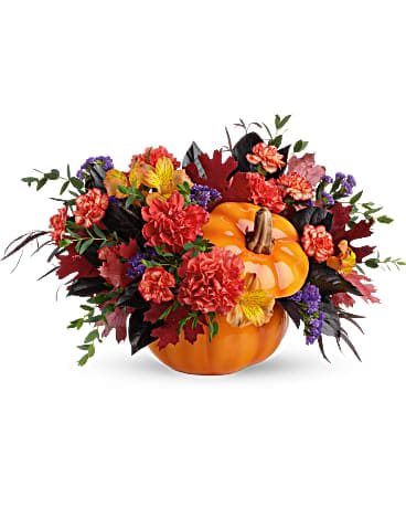 Teleflora's Hauntingly Pretty Pumpkin Bouquet - Bursting from a gorgeous glazed ceramic pumpkin bowl, this fabulous fall mix of alstroemeria and carantions is a hauntingly beautiful addition to your autumnal gatherings! This bouquet features orange alstroemeria, dark orange carnations, miniature orange carnation, purple sinuata statice, parvifolia eucalyptus, red agonis, and lemon leaf. Delivered in a Trick &amp; Treat Pumpkin.