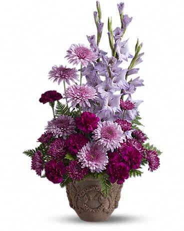 Teleflora's Heartfelt Memories - A towering display of blooms such as gladioli, carnations and chrysanthemums in royal hues of purple and lavender, presented in a Grecian-style urn, is a gracious representation of your heartfelt sentiments at a funeral, memorial service or wake. A mix of fresh flowers such as gladioli, carnations and cushion spray chrysanthemums, in shades of lavender and purple - accented with ferns - is delivered in a Teleflora Garlands of Grace urn.