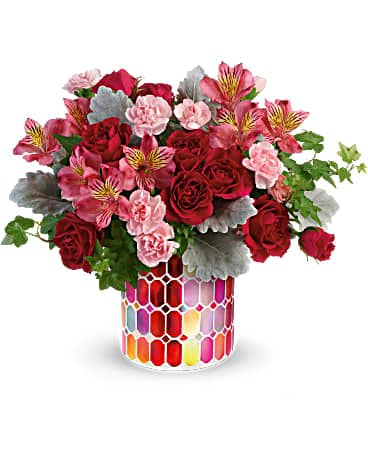 Teleflora's Mosaic of Love Bouquet - They're sure to swoon when this sweet rose bouquet arrives in a stunning stained glass mosaic vase! This arrangement includes hot pink spray roses, pink alstroemeria, miniature light pink carnations, green ivy and dusty miller. This pink and red bouquet is delivered in Charming Mosaic Cylinder.