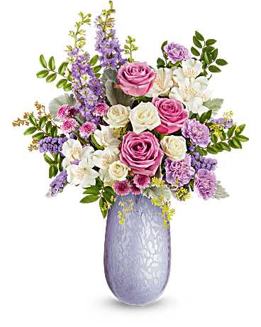 Teleflora's Pastel Elegance Bouquet - Surprise Mom with the timeless beauty of the Vivi vase, crafted from hand-blown art glass with an iridescent finish. A stunning keepsake, it perfectly complements a bouquet of soft, elegant blooms. The Pastel Elegance Bouquet features lavender roses, white spray roses, white alstroemeria, lavender carnations, larkspur, button spray chrysanthemums, sinuata statice, dusty miller, huckleberry, and seeded eucalyptus. Arranged in the hand-blown iridescent Vivi vase, it's a timeless Mother's Day gift.