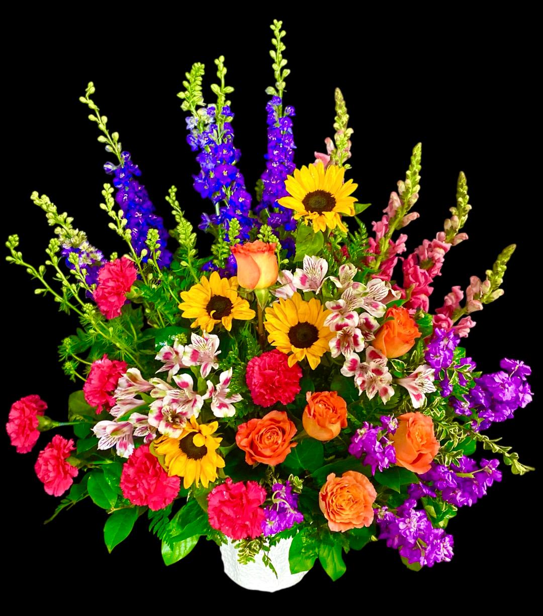 Vibrant Expression floor basket Vibrant Expression floor basket - The perfect bright floor basket to commemorate that vibrant personality. This colorful basket includes Sunflowers, Orange Roses, Hot Pink Carnations, Purple Larkspur, Pink Snapdragon, Purple Stock, and Alstroemeria. All set in a Mache container and accented with various foliage. This design measures approx. 25"W x 30"H.