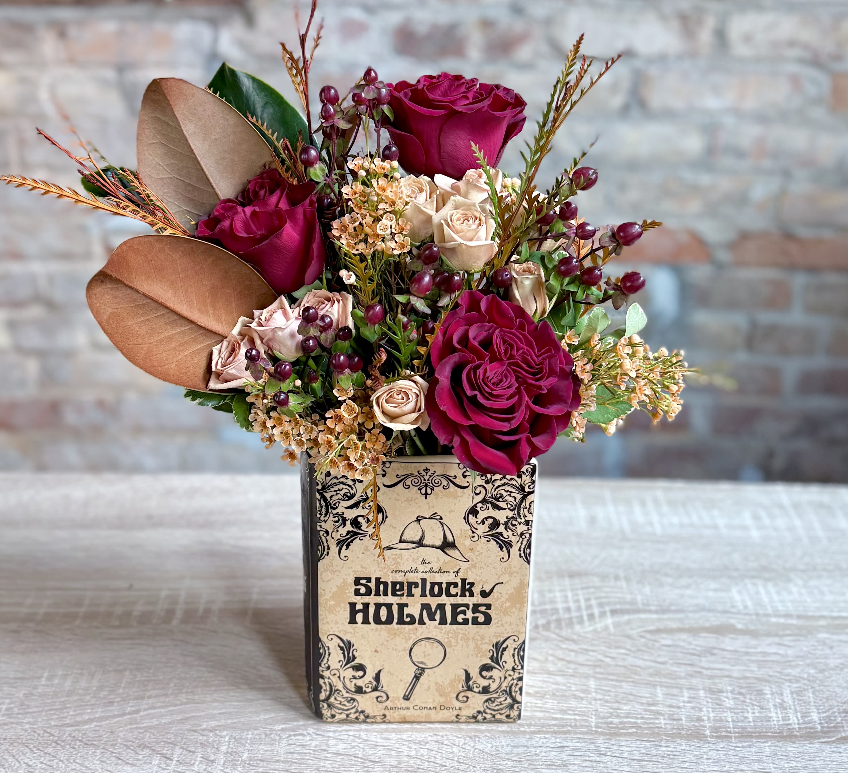 Sherlock Holmes Book Vase Sherlock Holmes Book Vase - Our newest book vase of Sherlock Holmes! Filled with Autumn colors, deep red roses, berries magnolia leaves and spray roses.