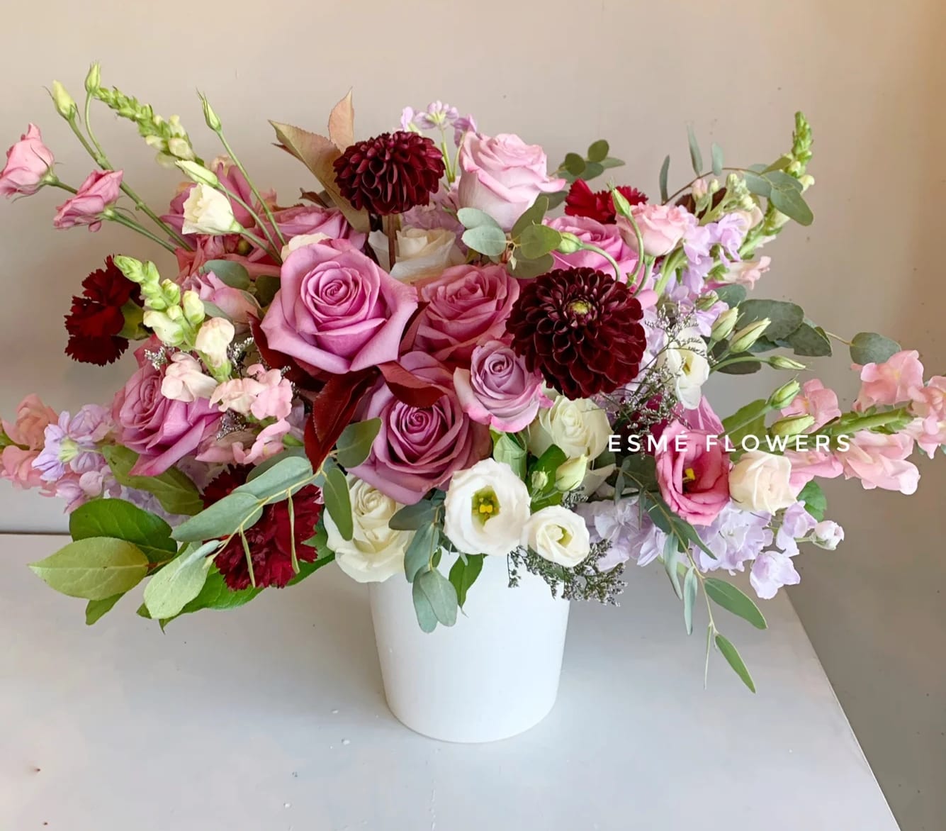 Ember - Ember is a beautiful asymmetric collection of soft lavender and pink blooms, dalias, lisianthus, premium roses, and gentle pink snapdragons. A warming invitation to the autumn season.