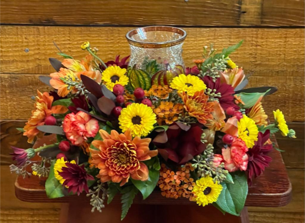 Festive Fall w/ Votive Candle -  A  Mixture of Fall Colors Flowers with a Festive Votive Candle in the Center 