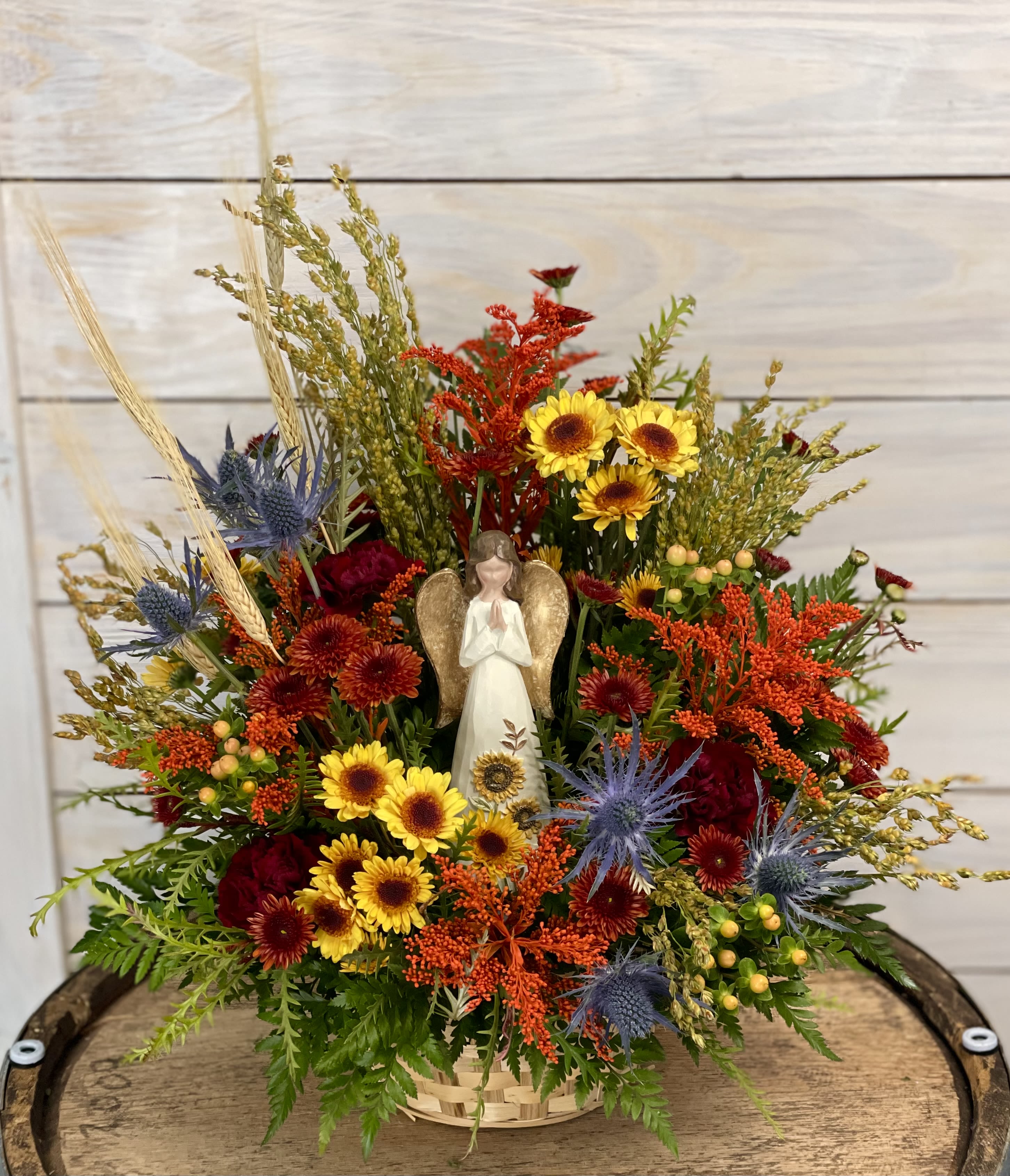Peaceful Autumn - A basket full of fall flowers with a angel at the center.