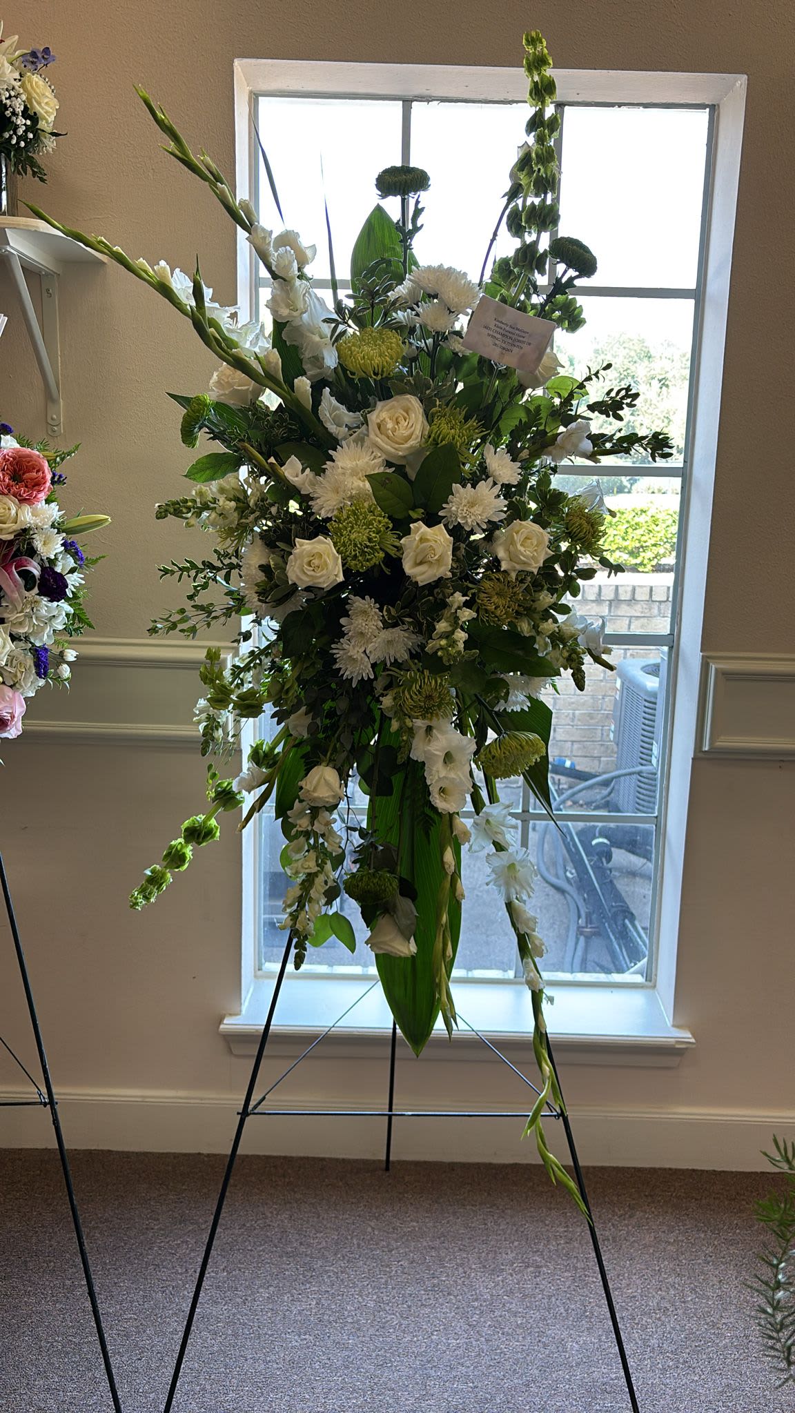 Funeral Spray Standing White - The Funeral Spray Standing White is a graceful tribute, featuring elegant white blooms and lush greenery arranged in a standing display to honor and remember a loved one with dignity and peace.