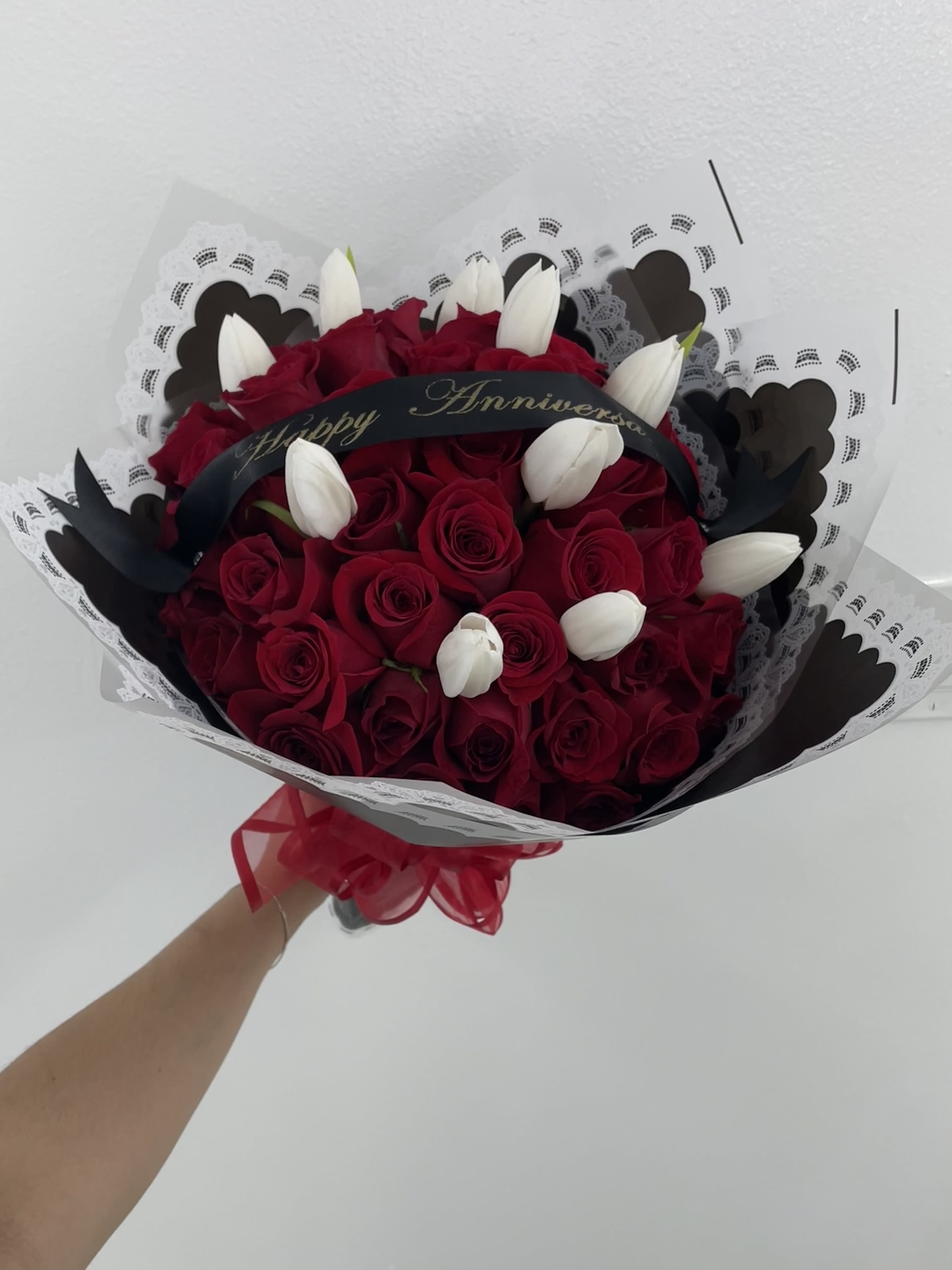 Red Ramo Buchon With Tulips Red Ramo Buchon With Tulips - Beautiful Ramo Buchon in red of 50 roses with ribbon and tulips- color of tulips may change due to what's in stock! If you'd like a specific saying on the ribbon or color of paper please add it to notes. (Does not come in a vase, this is a wrapped bouquet. The stems will also be wrapped in paper with bow on the bottom. If paper is not available, we will pick one similar.)