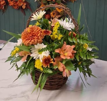 Basket Full of Fall - Celebrate the beauty of the season with our Basket Full of Fall bouquet. This charming arrangement is artfully designed in a rustic basket and filled with a delightful mix of fresh, seasonal fall flowers — perfect for adding a touch of autumn warmth to any space.  Please note: Flower varieties and colors may vary based on seasonal availability. Substitutions will be made with flowers of equal or greater value while maintaining the overall look and feel of the arrangement.