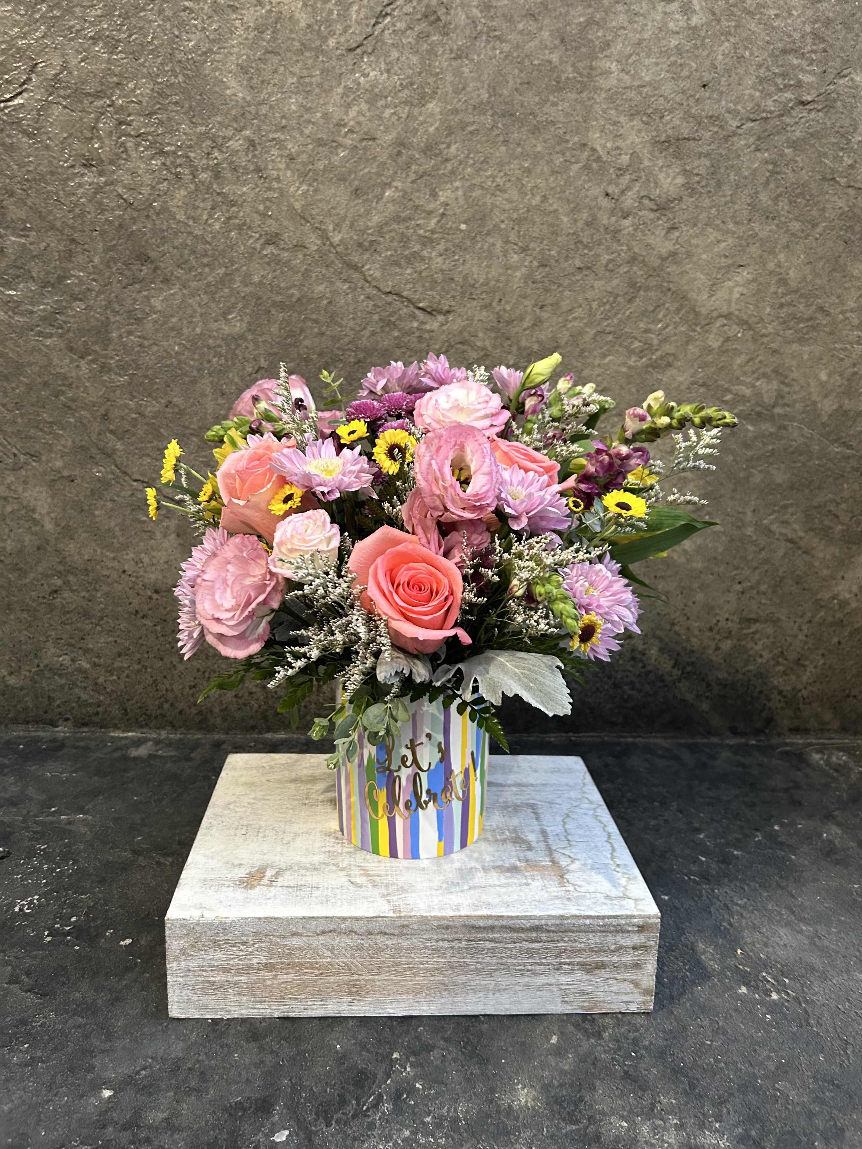 Lets Celebrate! Lets Celebrate! - Colorful vase with 'Lets Celebrate" filled with Lisianthus, pink roses, snap dragons, micro sunflowers* blooming fillers and greens. *Reasonable substitutions may be made due to flower availability. Will have similar look and feel.