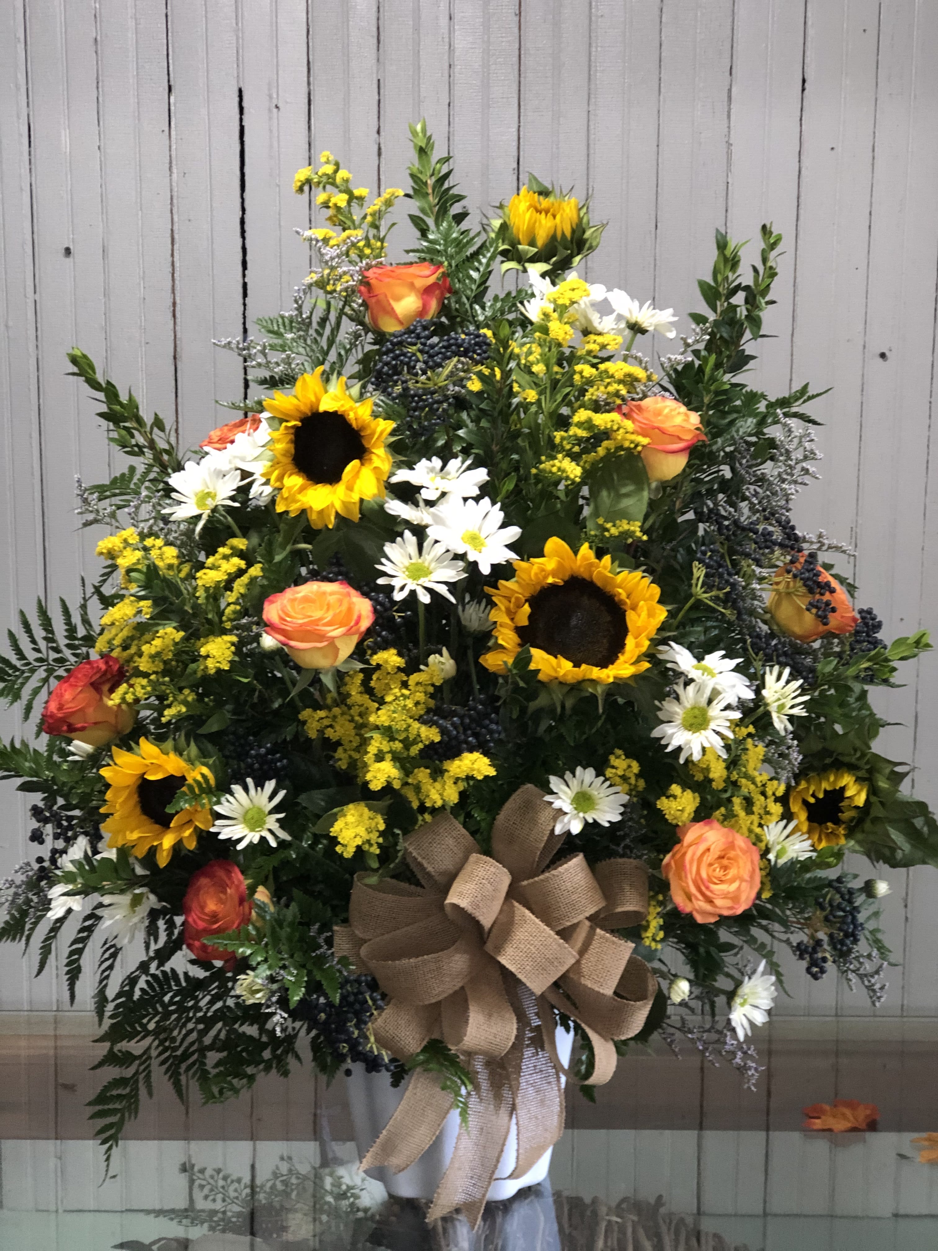 Sunflower Sympathies - A traditional sympathy spray with a rustic feel. Perfect for your loved ones who loved the country. ****We will try our best to match the flowers in the picture, but there may be times when we have to substitute flowers. We will always try to make it have the same look and feel as the original.