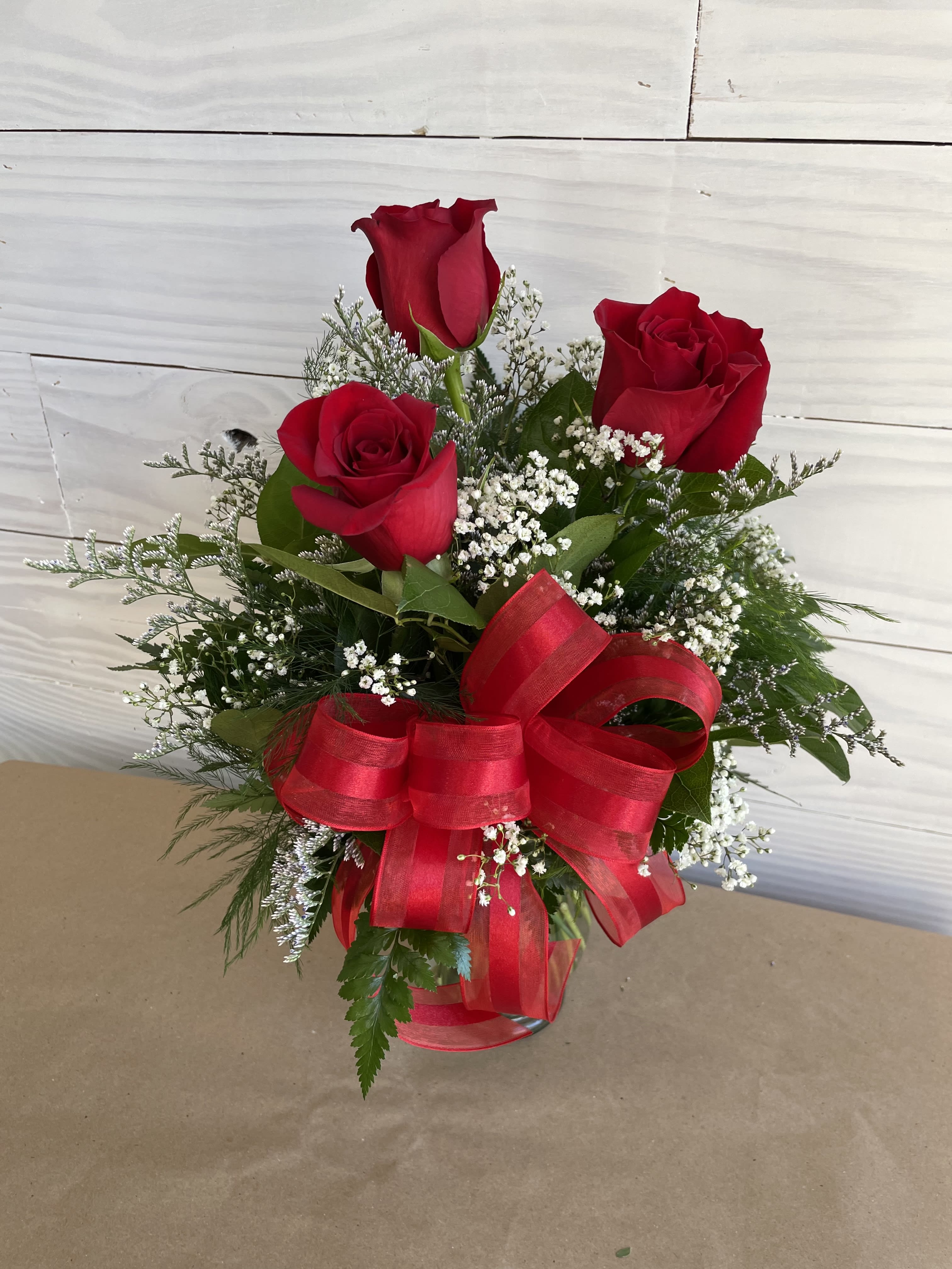 Sweetheart's Kiss - A 3 rose vase with a mixture of filler flower and a bow.  If you have a preference for a certain color, please add that to the notes and we will do our best at accommodating that request.  Please make first, second and third choices as well.