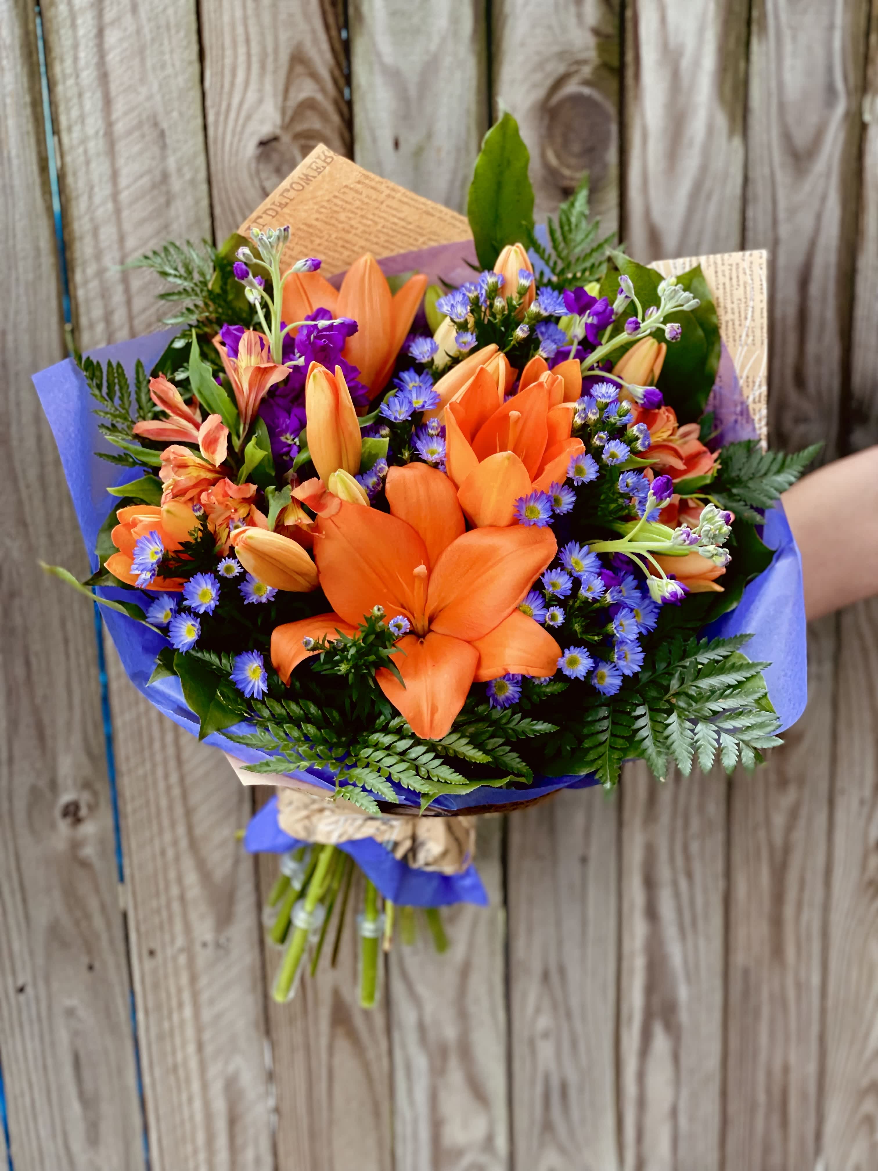 Monarch Meadow Wrap - Orange lilies with purple flowers make this wrap a favorite for many!  **Disclaimer*** Some orange lilies may arrive to recipient still closed. Lilies will eventually open as shown in the picture.