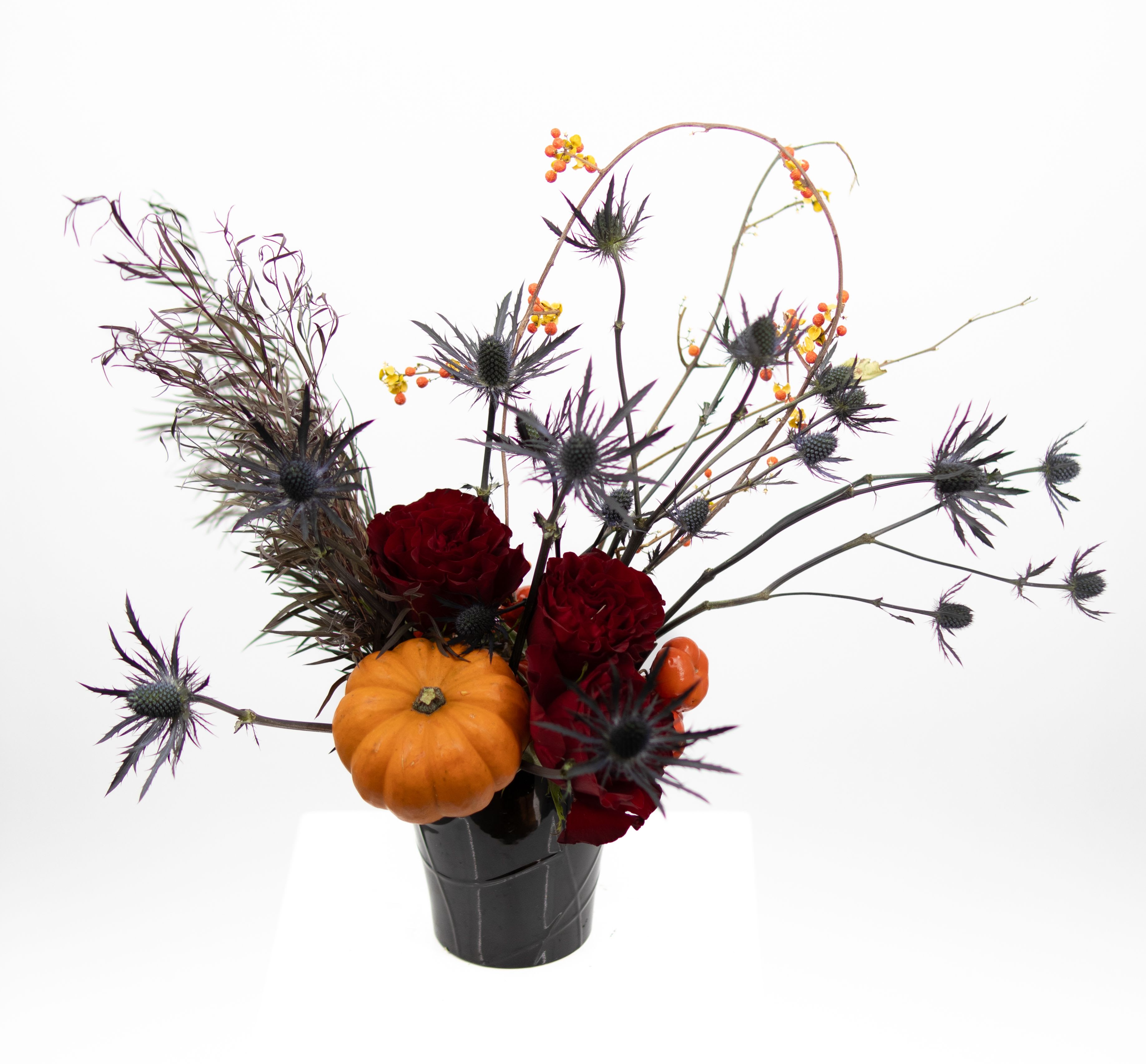 Uncle Fester - A moody autumnal arrangement featuring mini pumpkins, spiky spider thistle, rich garden roses, and bittersweet, blending seasonal textures for a bold and captivating display.