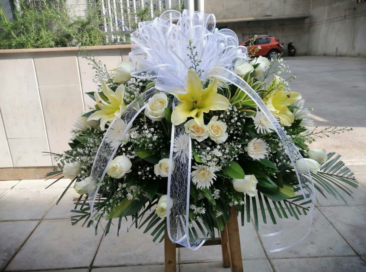 Arreglo de luz y recuerdo - Elegante arreglo funebre elaborado con rosas blancas, lirios amarillos, gipsofilia y follaje