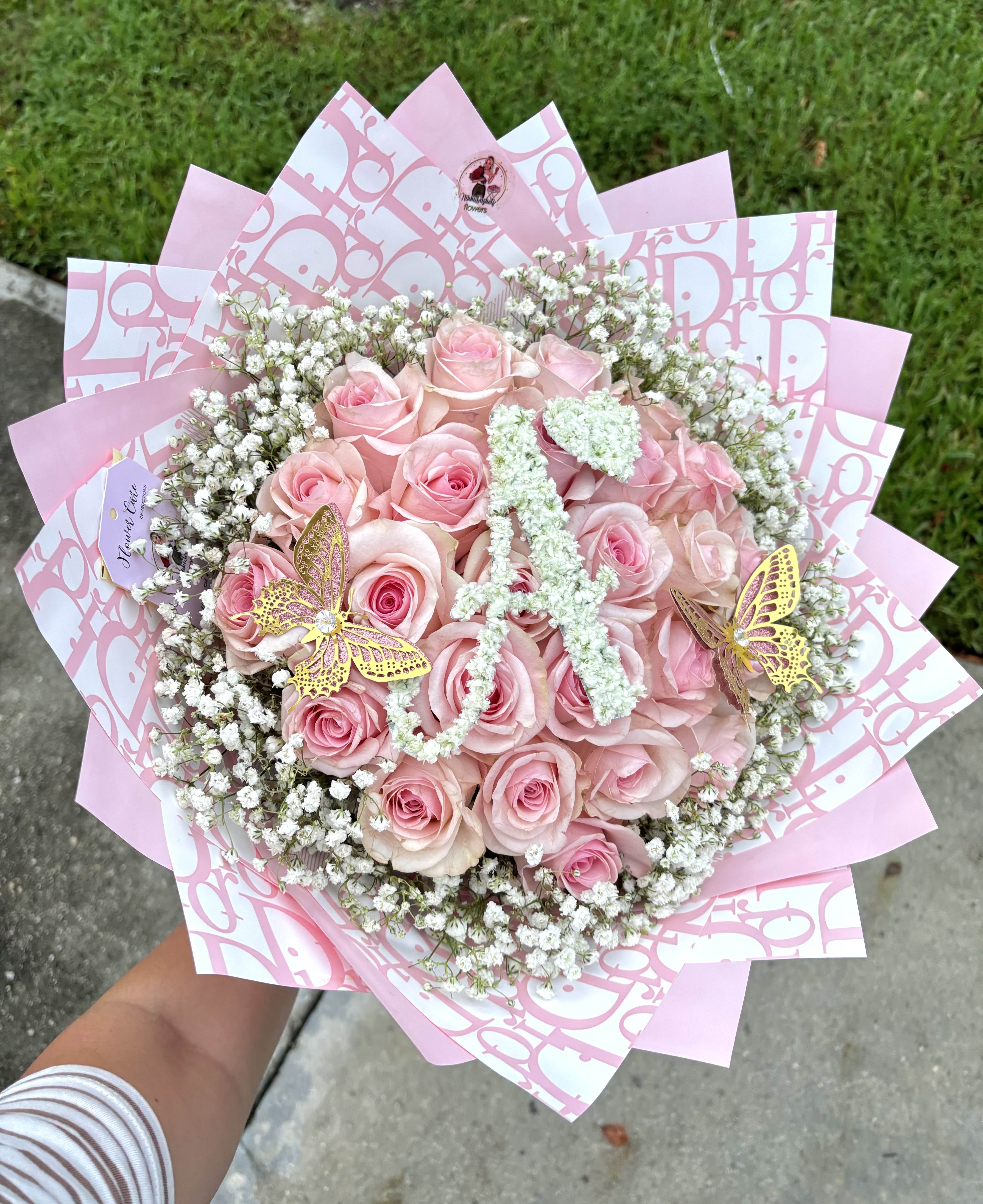 Initial Letter Pink Rose Bouquet with Baby Breath Rim Initial Letter Pink Rose Bouquet with Baby Breath Rim - Personalized Luxury Rose Bouquet Make every gesture unforgettable with our Personalized Luxury Rose Bouquet. This stunning arrangement features a romantic blend of premium red and soft pink roses, beautifully accented with delicate baby’s breath, all wrapped in chic designer-inspired paper for a touch of elegance. At the heart of the bouquet lies a custom floral initial, handcrafted with pristine white blooms to add a personal and meaningful detail — perfect for birthdays, anniversaries, proposals, or just because. Whether you’re celebrating love or sending a thoughtful surprise, this bouquet is designed to leave a lasting impression. Please note: Custom initial letter can be specified at checkout.
