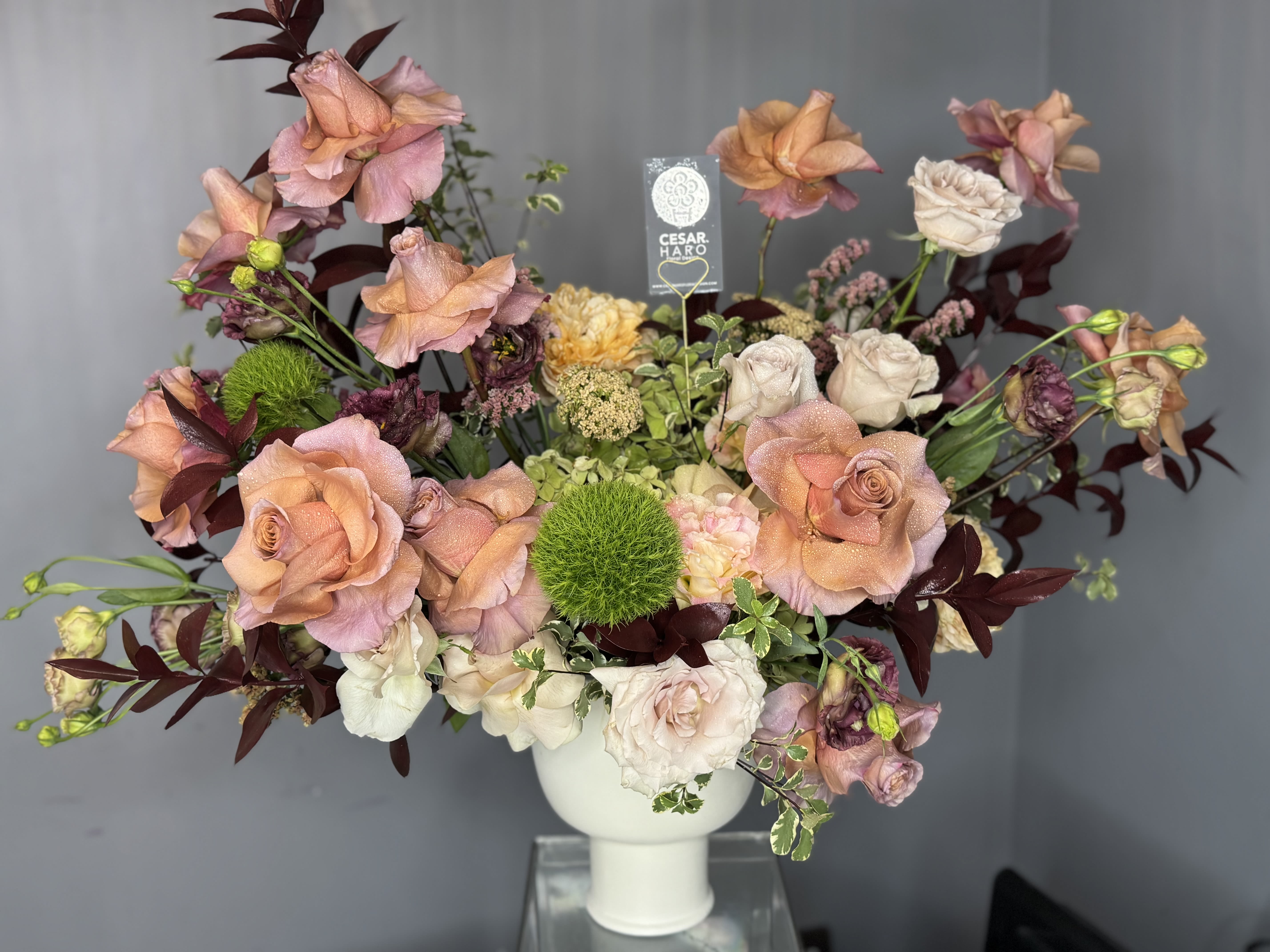 Fall Compote Design - Fall Colors beautifully designed in a ceramic compote vase with gorgeous mocha Caramels toffee roses and other seasonal flowers