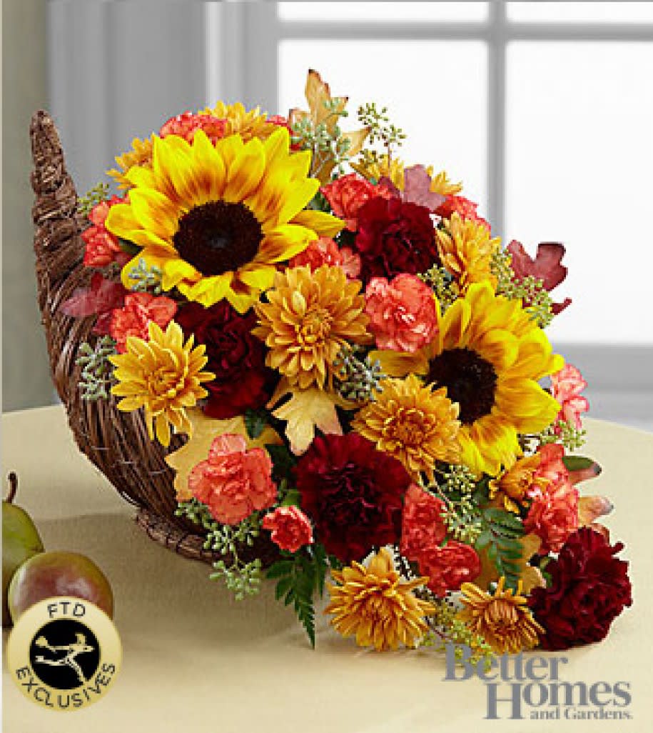 Fall Harvest Cornucopia Fall Harvest Cornucopia - Fall Harvest Cornucopia. Capture the essence of the autumn season with this inspiring and colorful arrangement. Rich red roses, bright and brilliant sunflowers, orange Asiatic lilies, burgundy carnations, orange mini carnations, butterscotch chrysanthemums, an assortment of lush greens, and glycerized oak leaf accents are beautifully arranged in a natural cornucopia basket that speaks of harvest traditions with each gorgeous bloom. It's the perfect Thanksgiving gift to send to friends and family throughout the fall season, showering them with love, gratitude and unforgettable beauty.