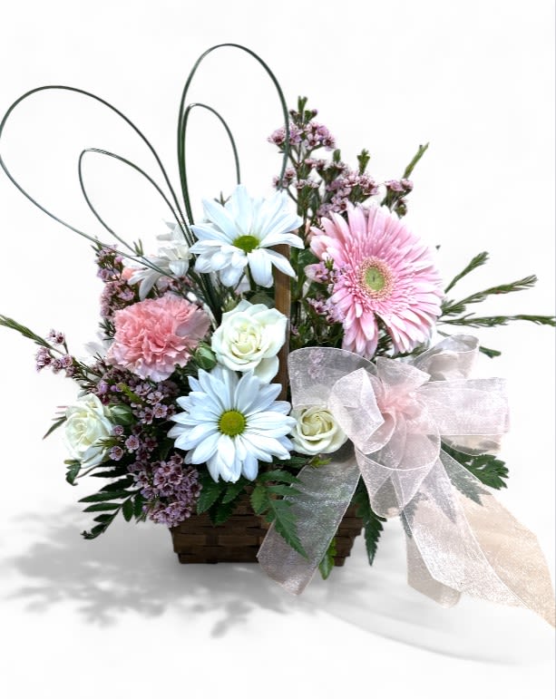 Love's Heartfelt Harmony Love's Heartfelt Harmony - Introducing "Love's Heartfelt Harmony," a delightful small basket arrangement perfect for Valentine’s Day! This charming display features cheerful pink and white carnations surrounded by sunny daisies, all wrapped in delicate wisps of baby's breath. The arrangement is embraced by heart-shaped grass, beautifully symbolizing true love, and tied together with a soft satin bow that adds an enchanting touch. It's a sweet tribute to romance, sure to bring joy and warmth to anyone's special day!