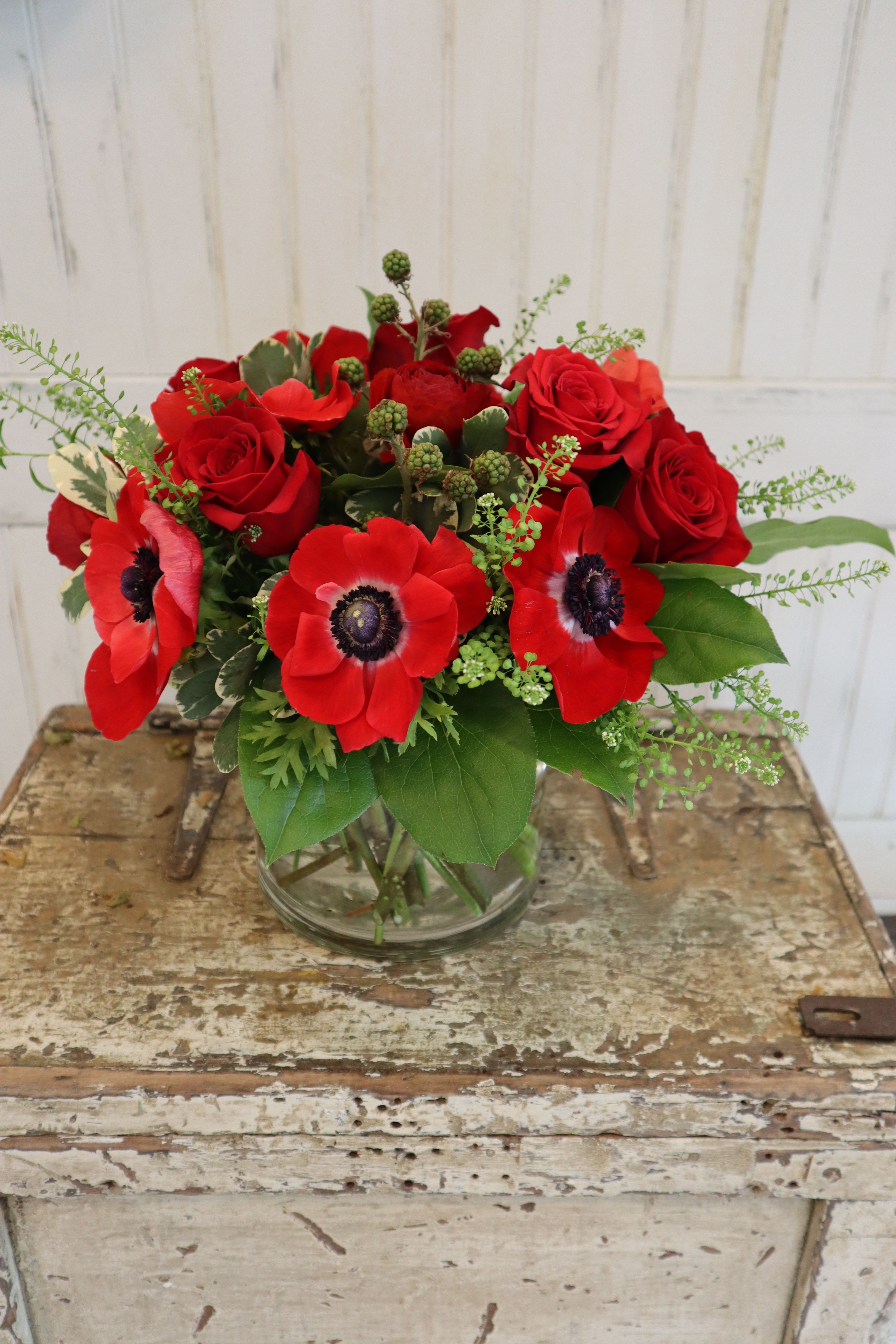 Red Bliss Red Bliss - Anemone, and roses with berries in a vase.