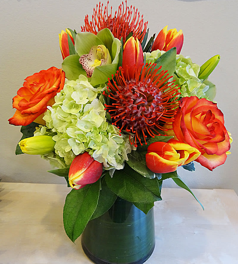 Green & Tangerine Green & Tangerine - A modern spring mix of florals in lime green & tangerine. Tulips, cymbidium orchid blossoms, pincushion protea, roses, and hydrangea or other flowers depending on the fresh mix of the day.
