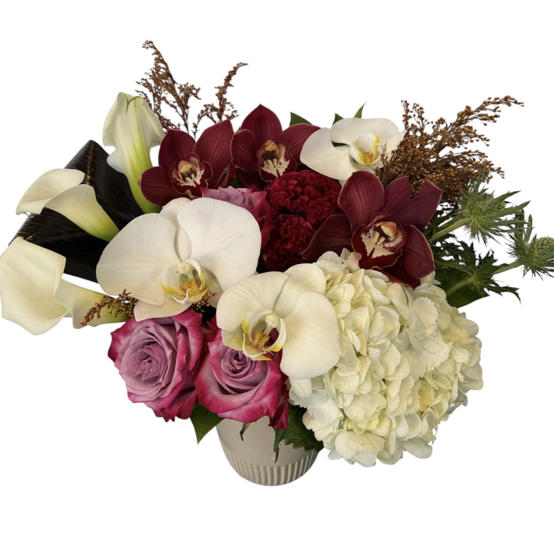 Harvest Moon Harvest Moon - White calla lilies, white orchids, red orchids, white hydrangea, blue thistle and purple rose designed in a tan colored vase. As shown in photo.