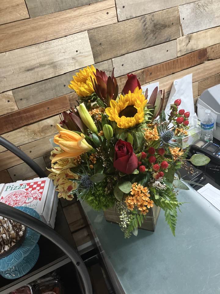 All Boxed Up - A garden of mixed flowers of various textures and colors to complete this wonderful arrangement. Some of the flowers that might be included will be hydrangea, calla , delphinium,  gerbera or sunflowers, berries, and other garden flowers.  