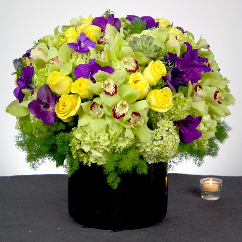 Happy Moments (DL) - Capture the essence of elegance and beauty with our exquisite arrangement featuring a perfect combination of yellow roses, green and purple orchids, and lush green hydrangeas.